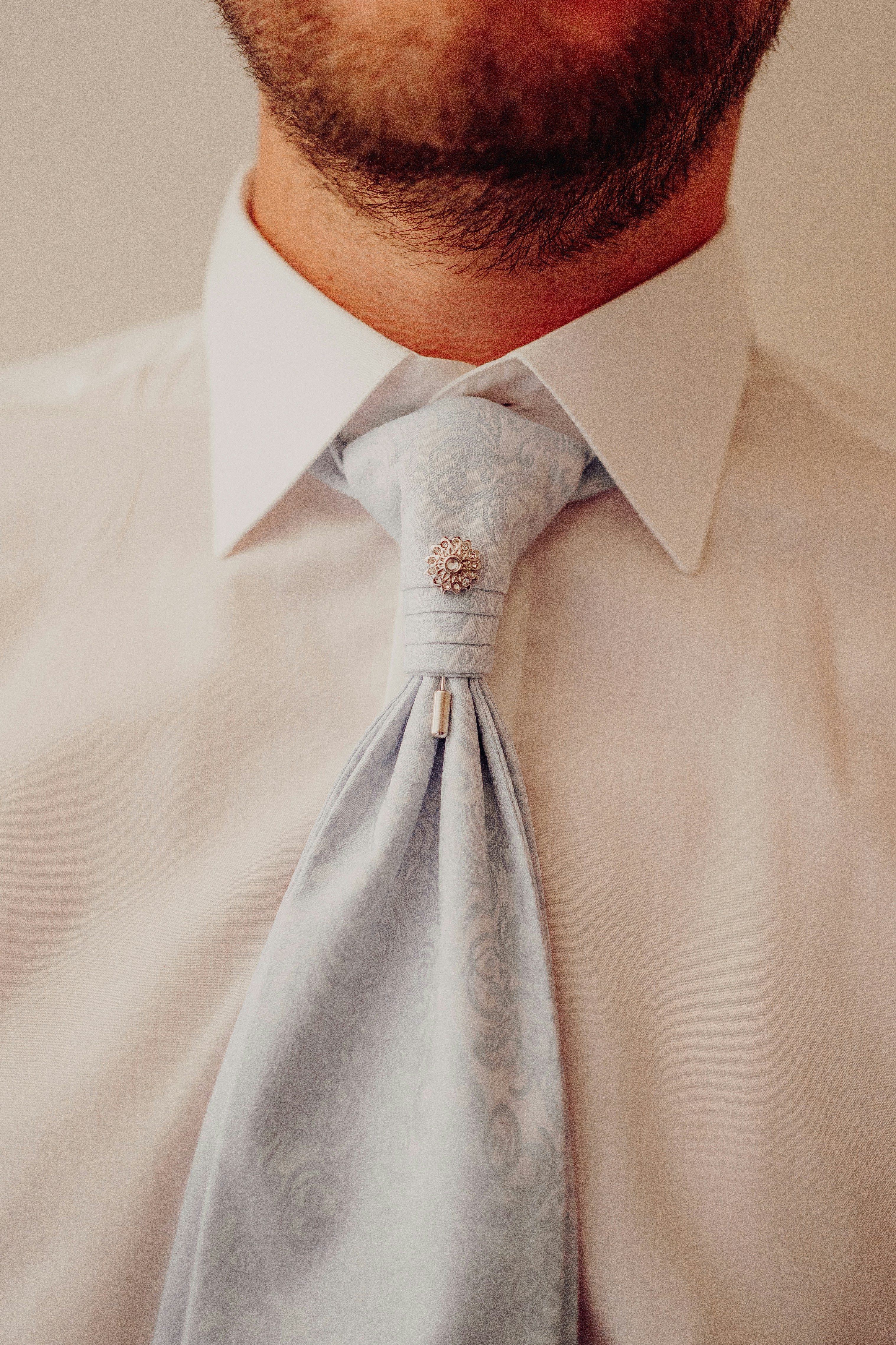 Kemeja putih pria dan cravat bermotif biru dengan jarum