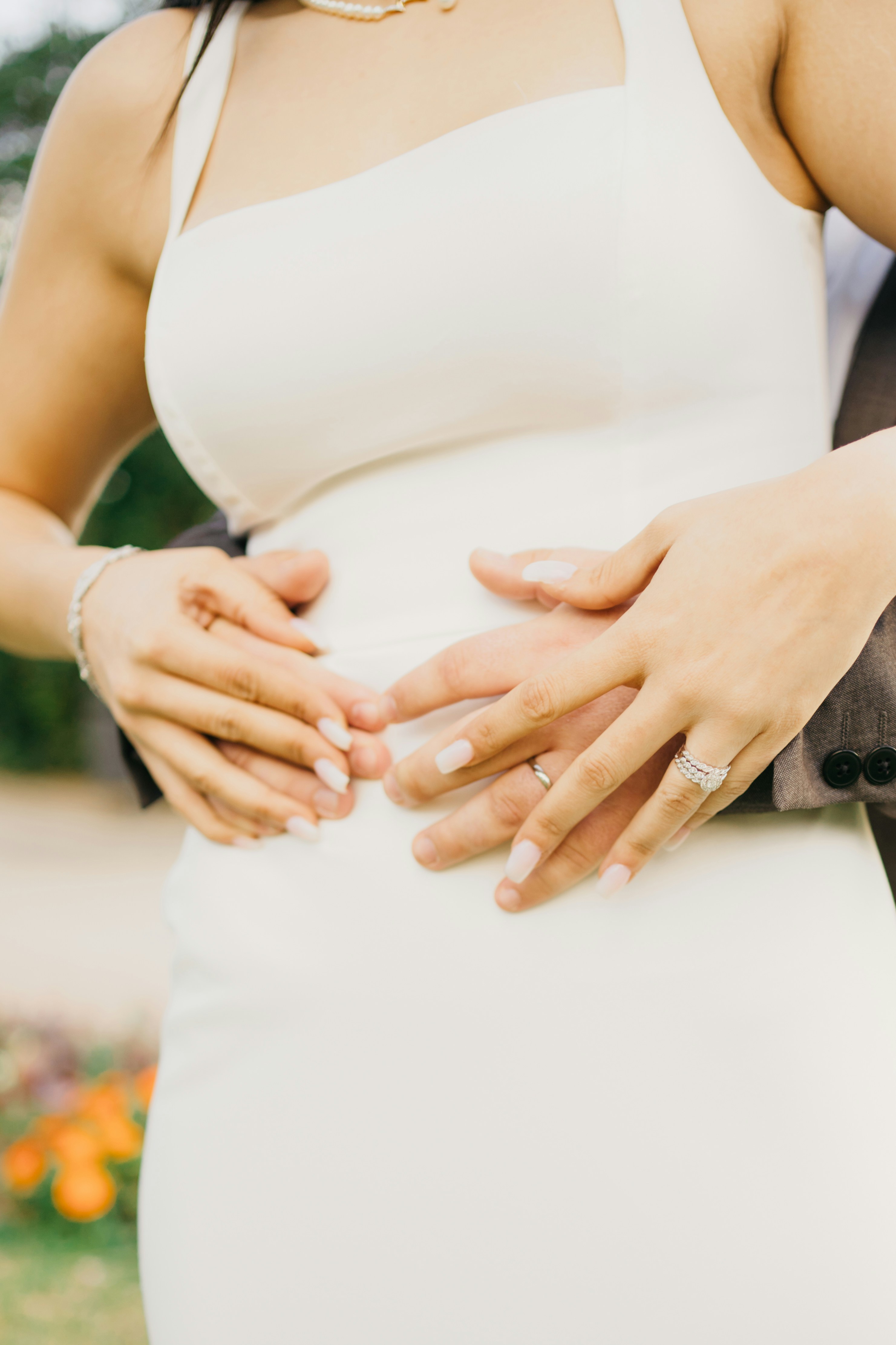 Tangan memeluk pinggang wanita dengan gaun putih