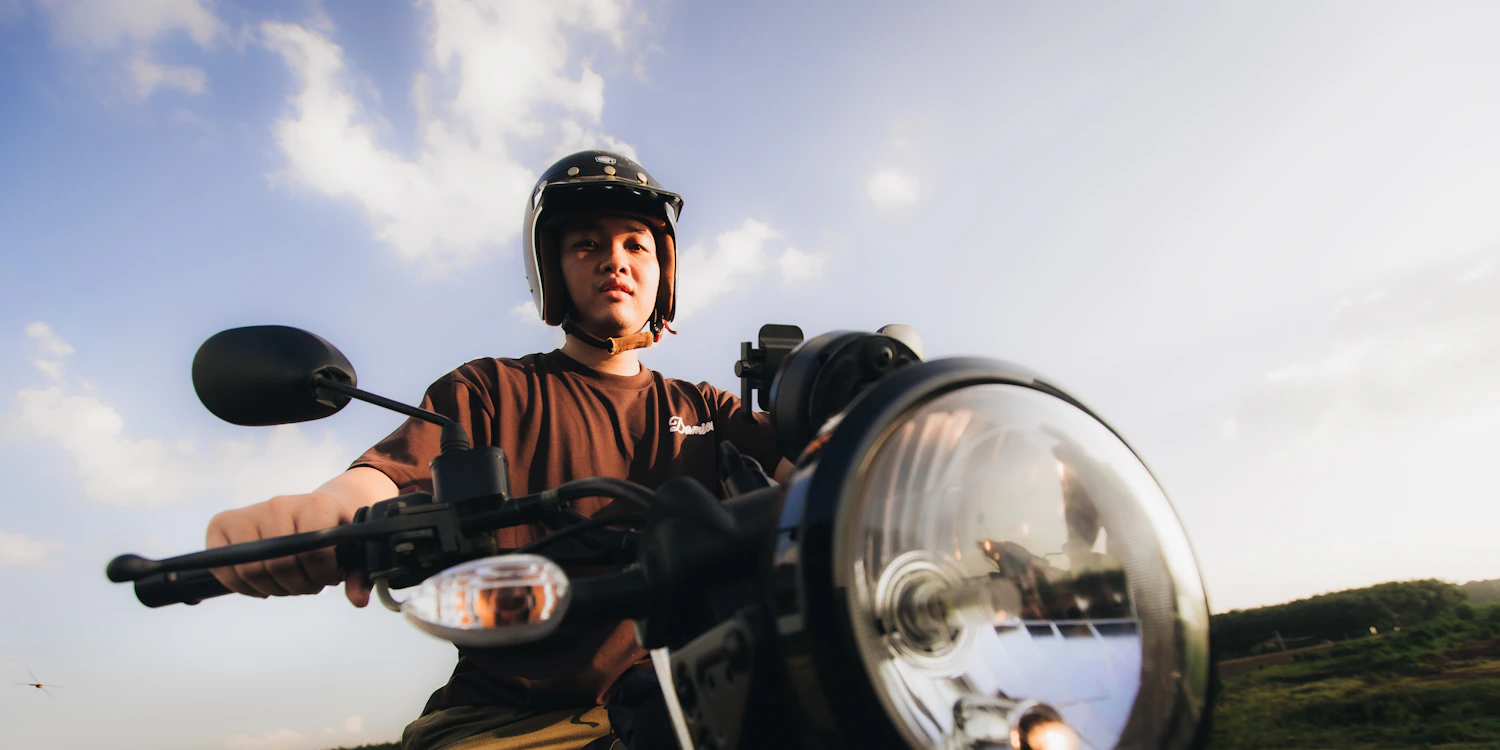 Helmeted scooter rider traveling outdoors