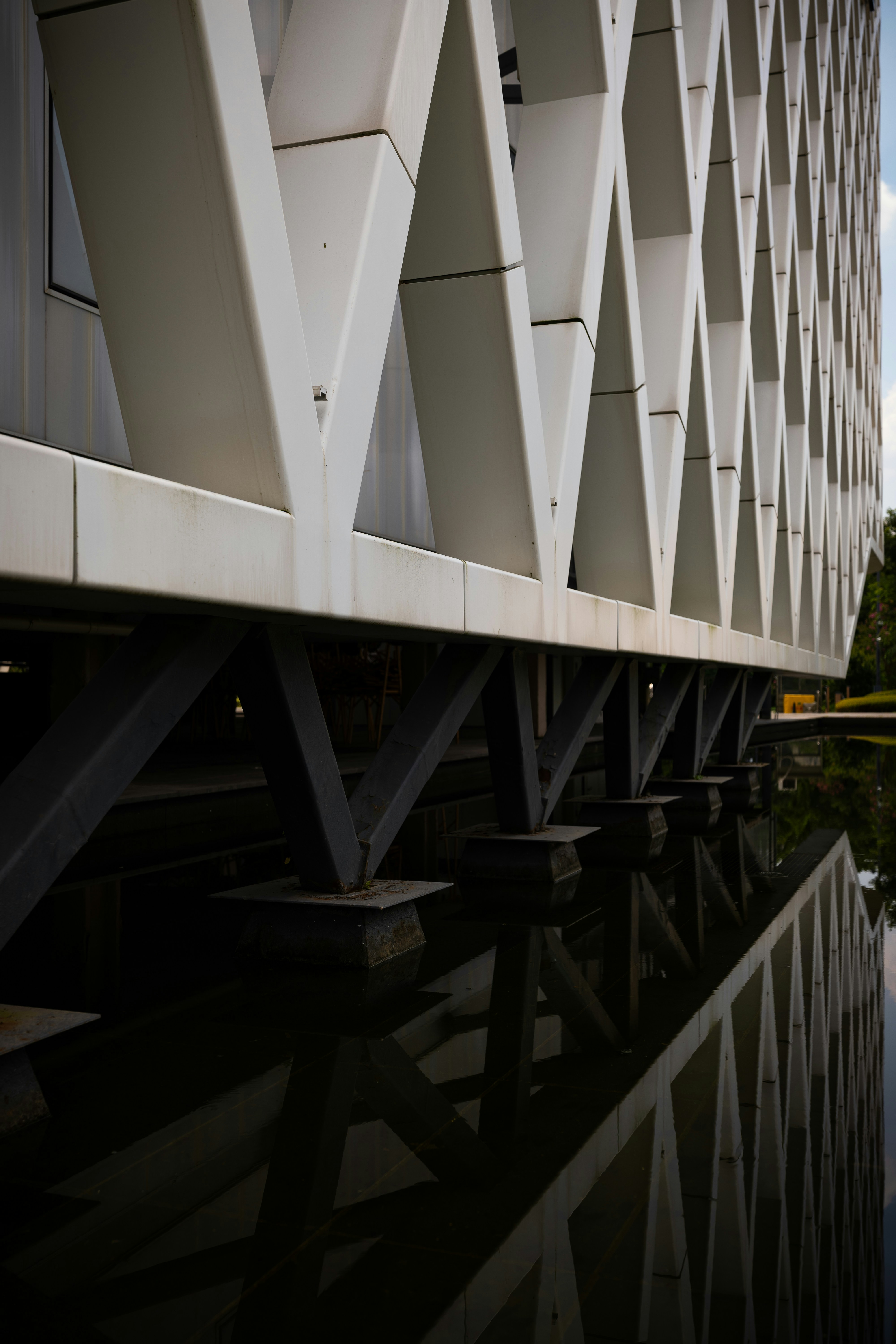 Geometric building facade reflecting in dark water