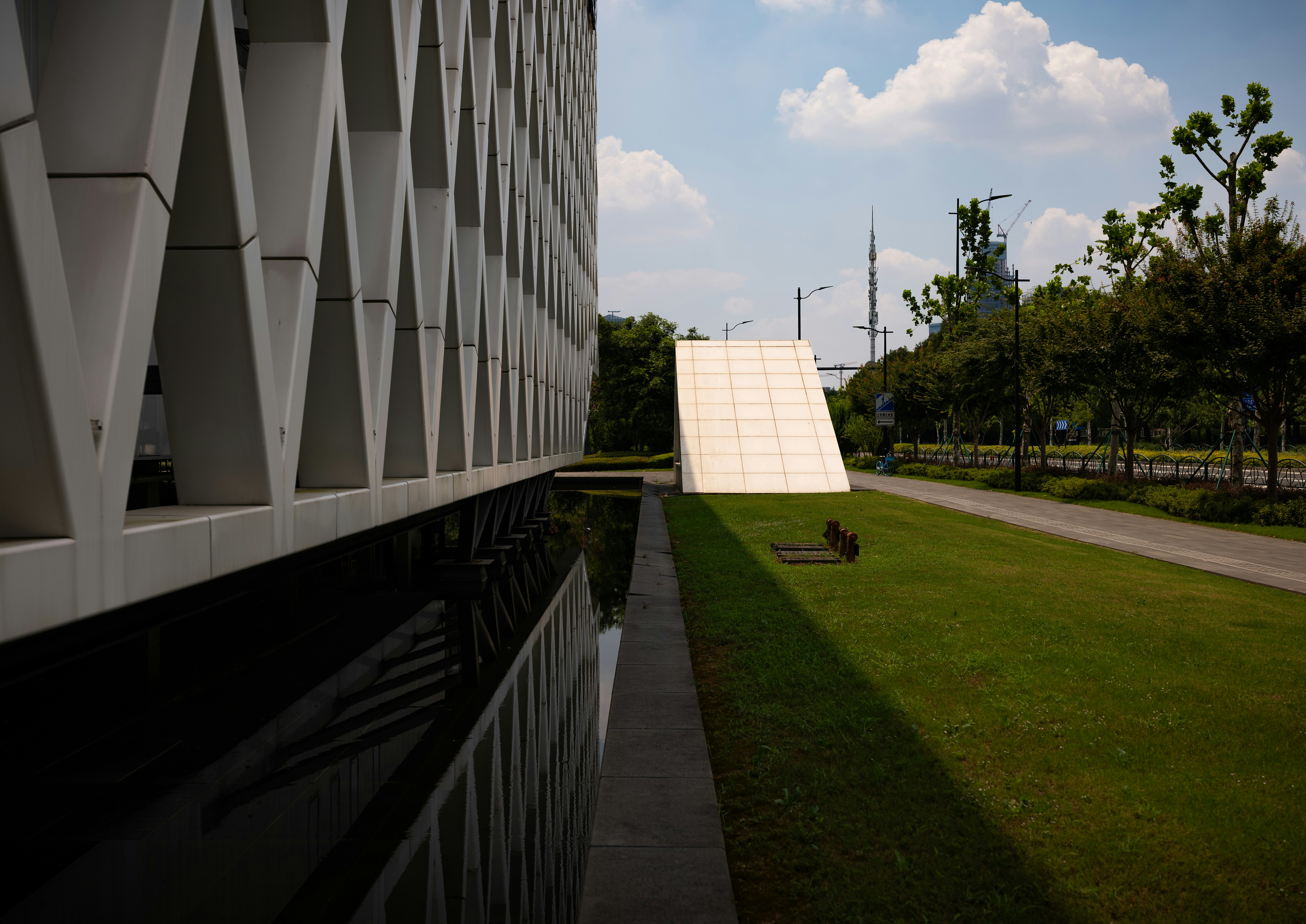 Geometric building facade, reflective base, and sloped white structure