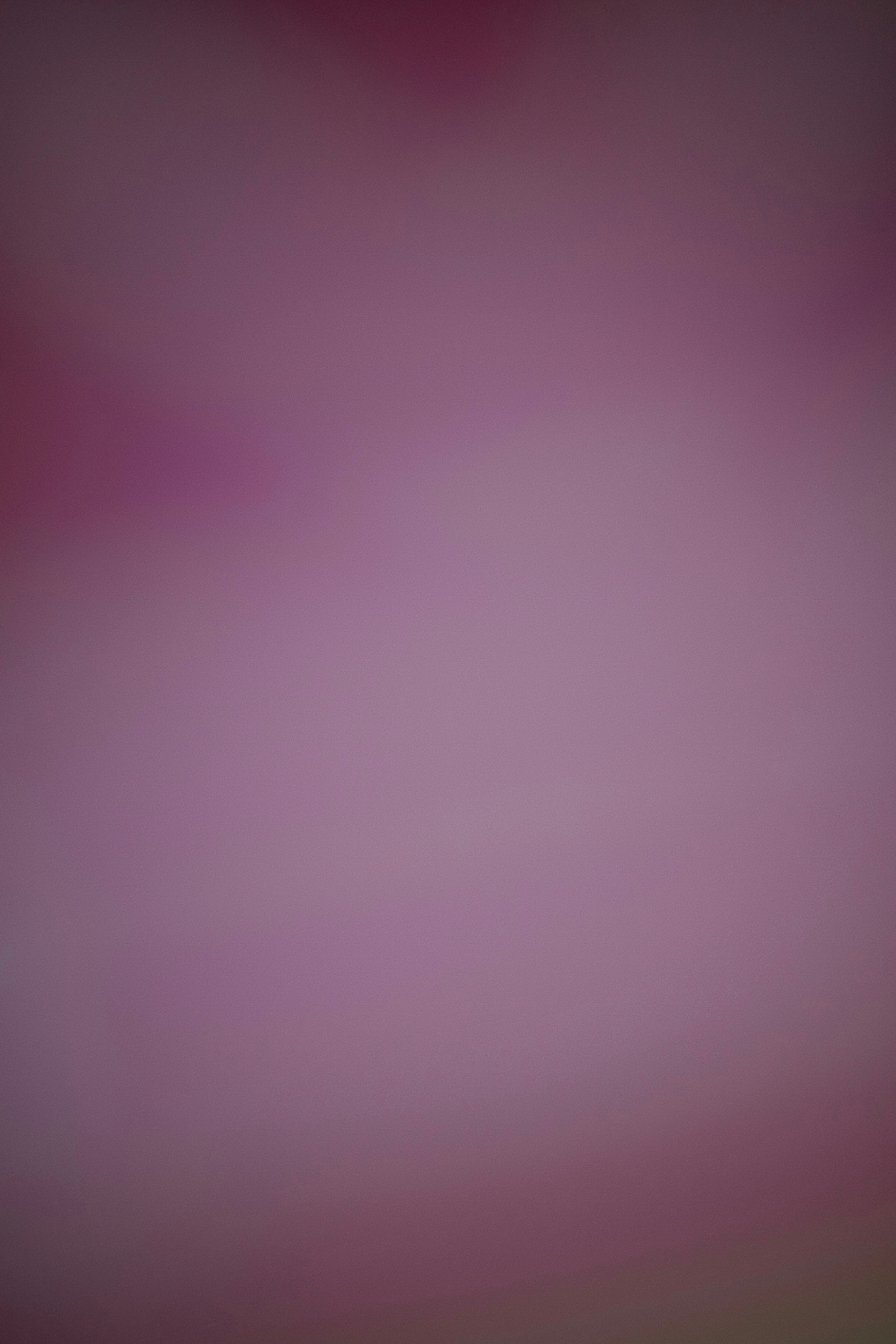 A blurry purple-pink background with soft gradients.