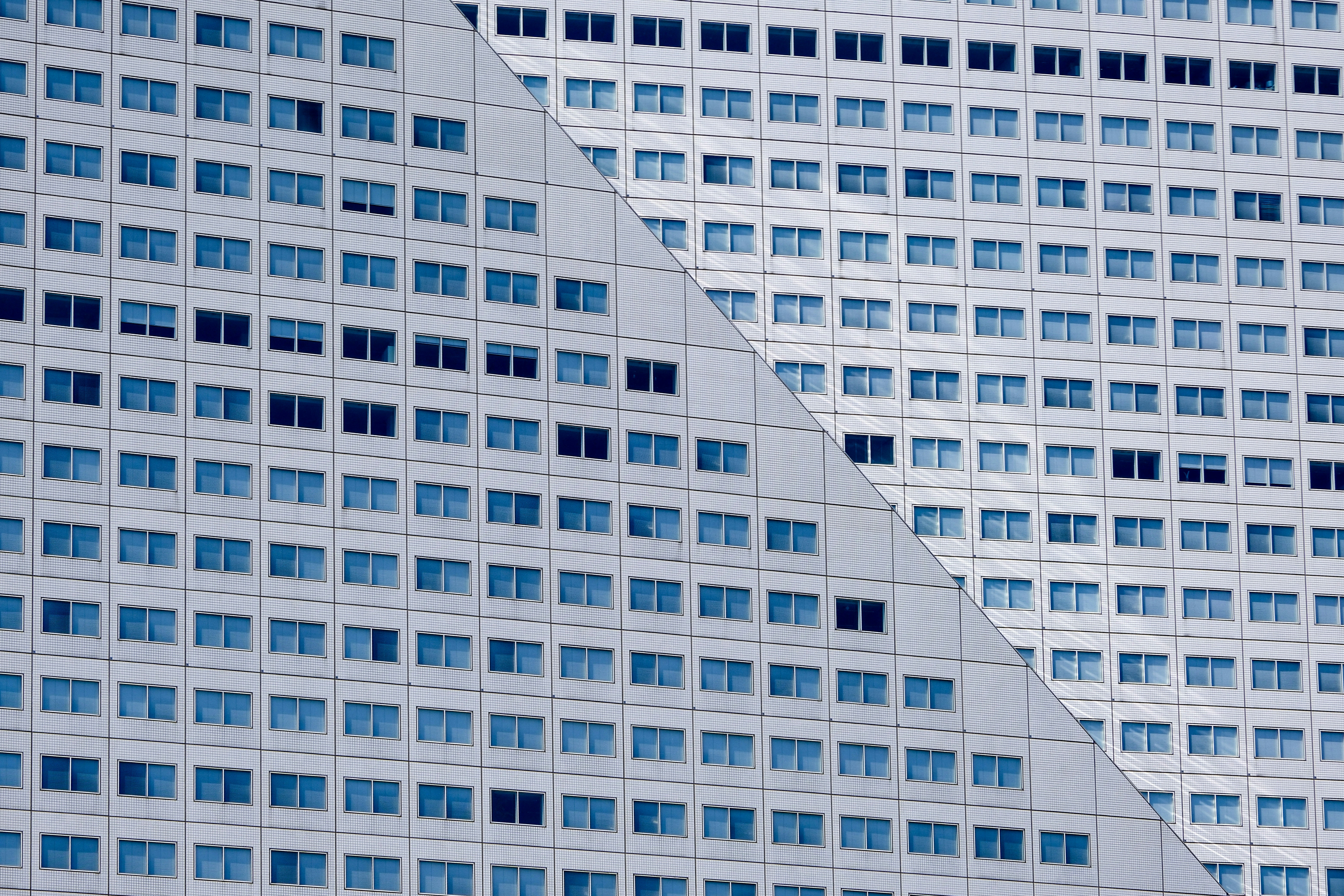Modern building facade with numerous windows and a diagonal line