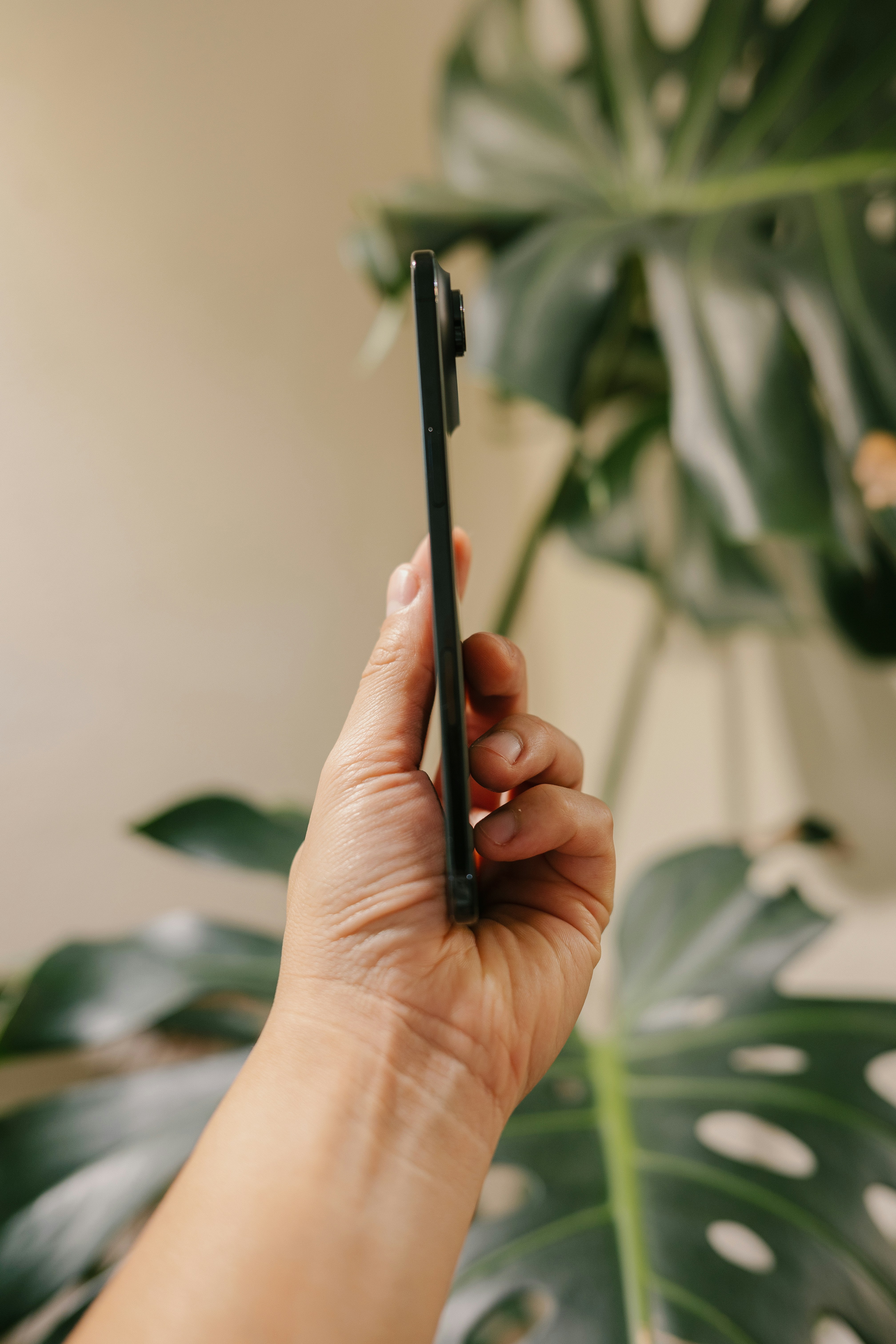Sujetando de la mano un smartphone delgado en perfil