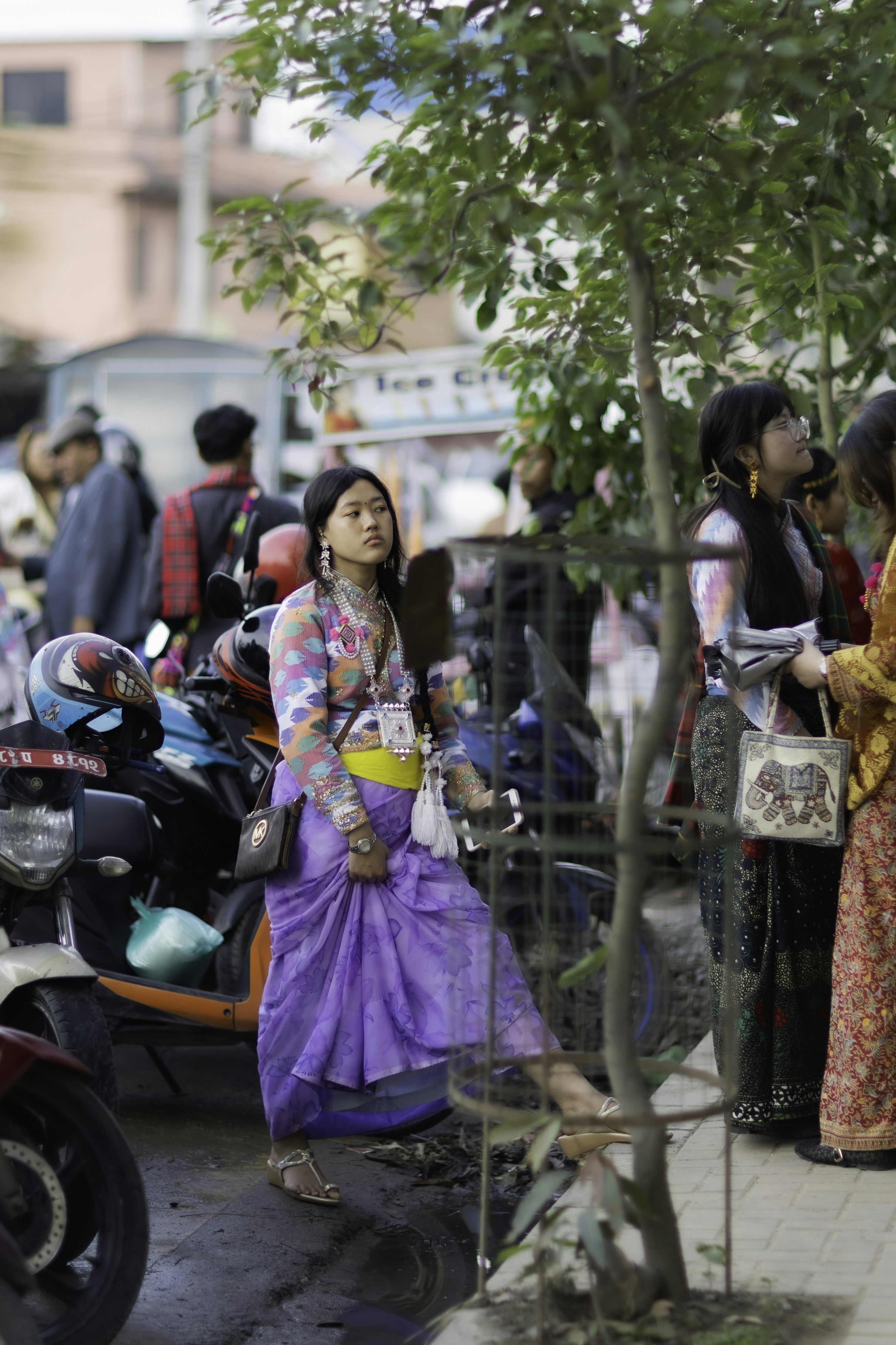 Young woman in purple traditional dress on a bustling street
