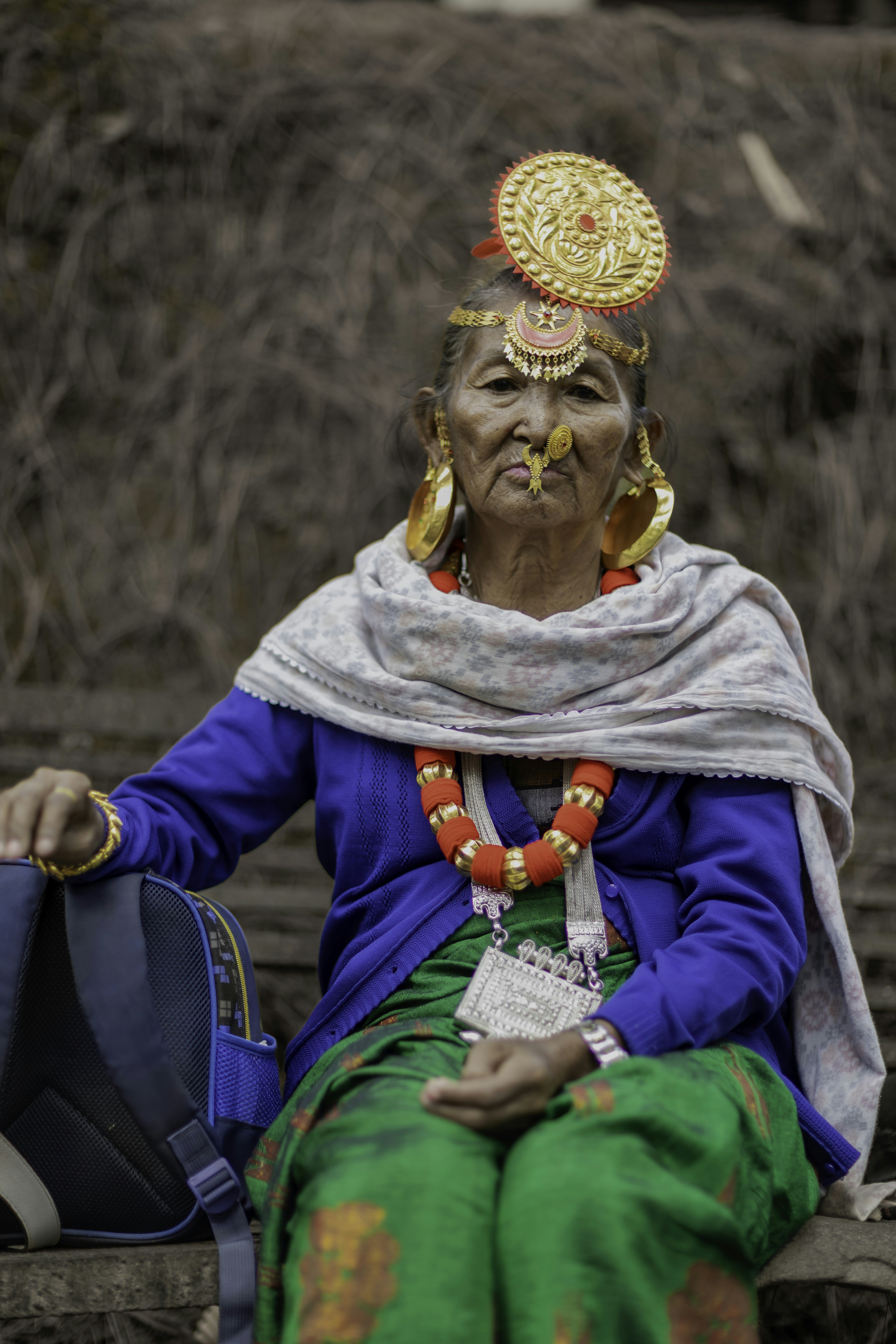 An elderly woman in traditional attire with a backpack