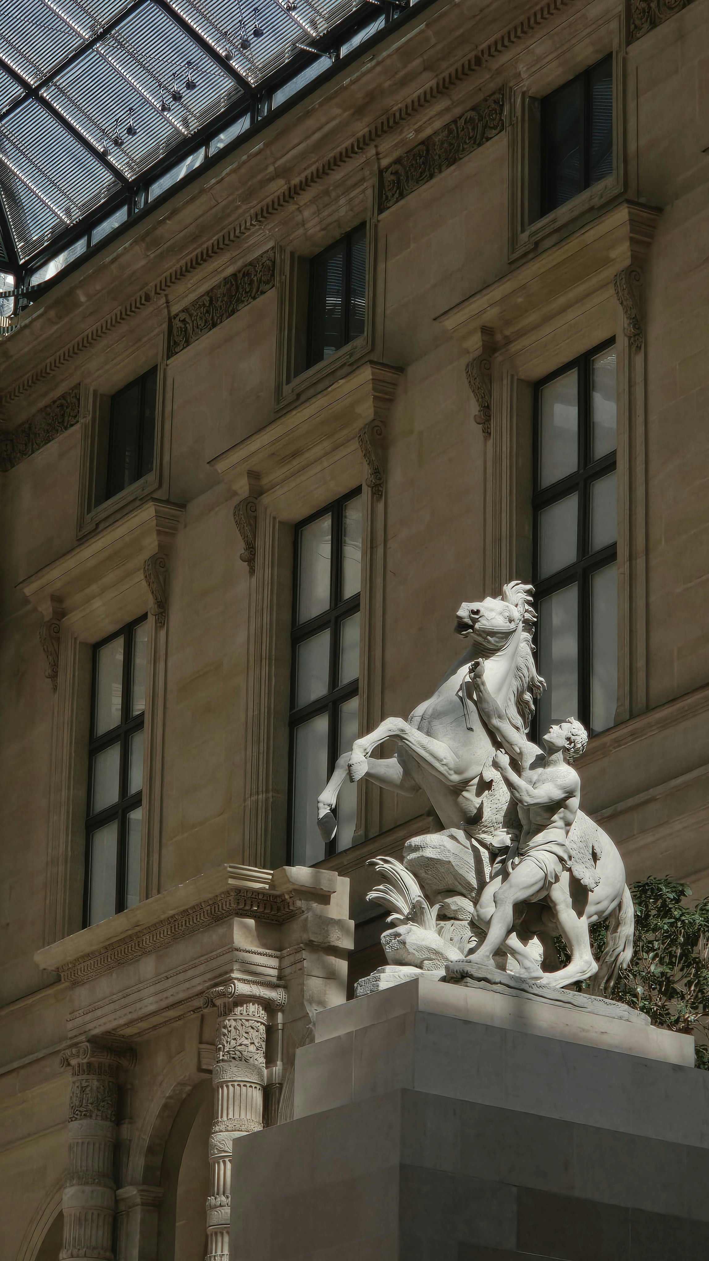 Intricate marble statue of a man and rearing horse.