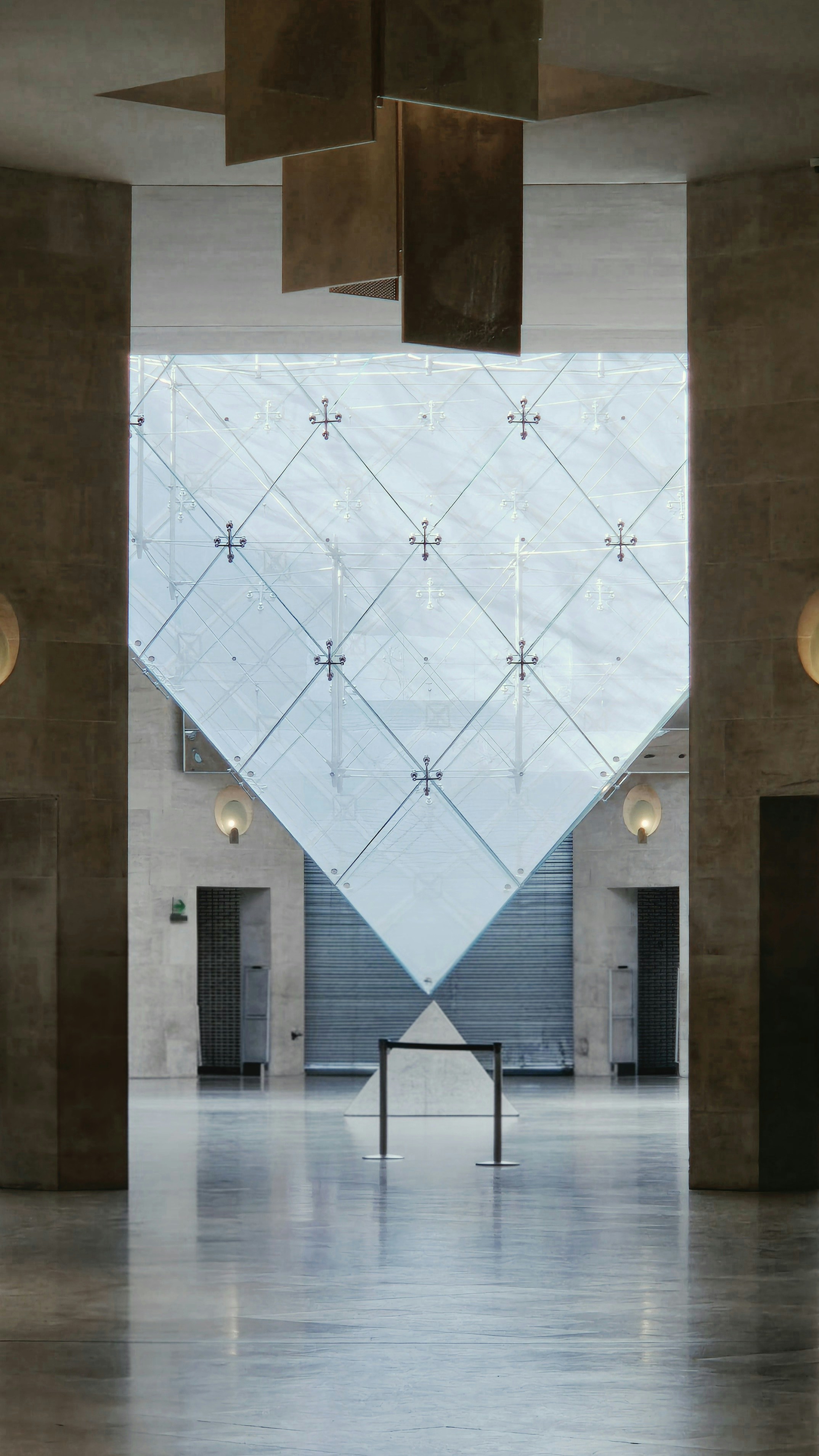 Modern interior with an inverted glass pyramid and reflective floor.
