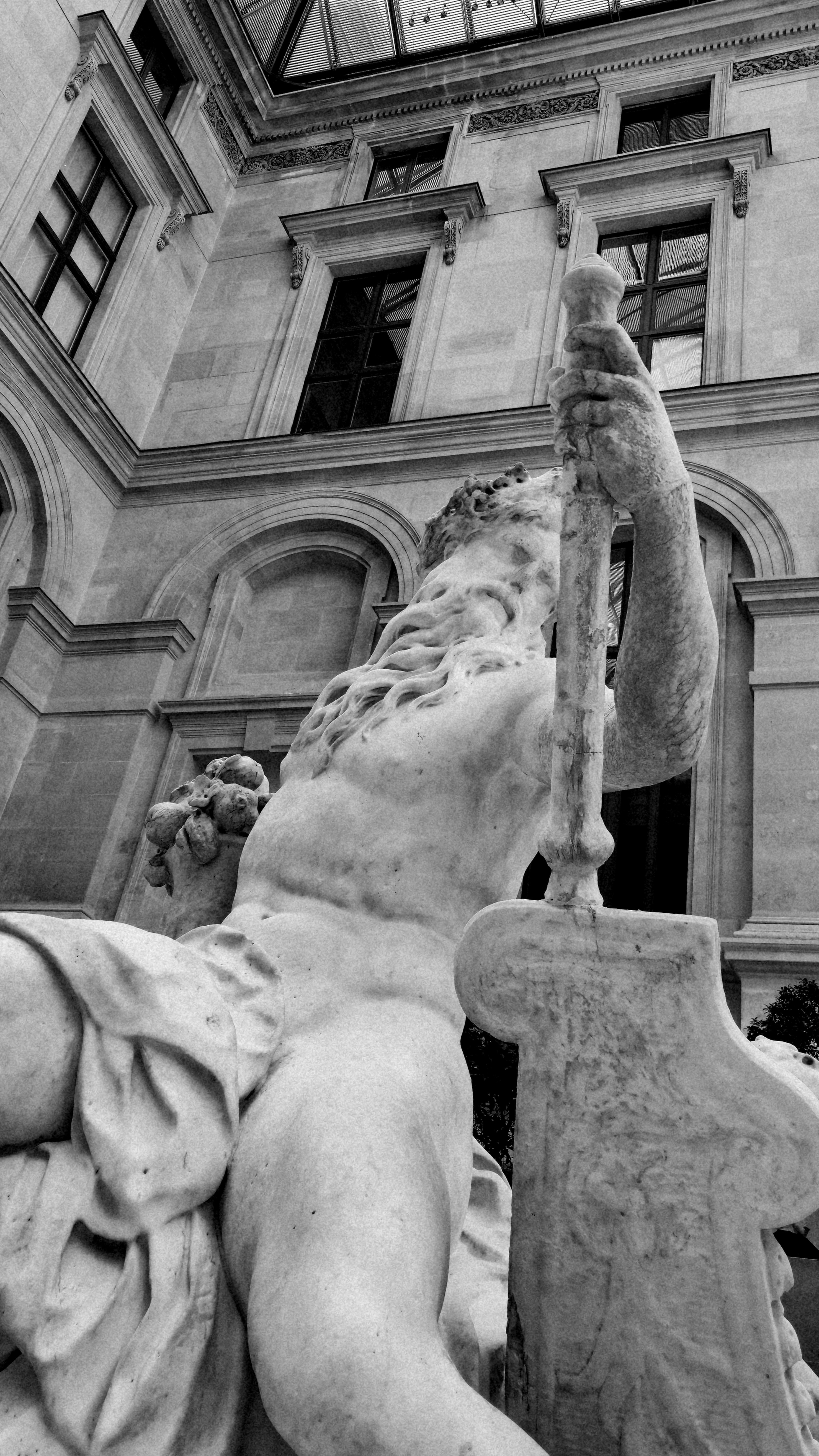 Black and white marble statue against an ornate building.