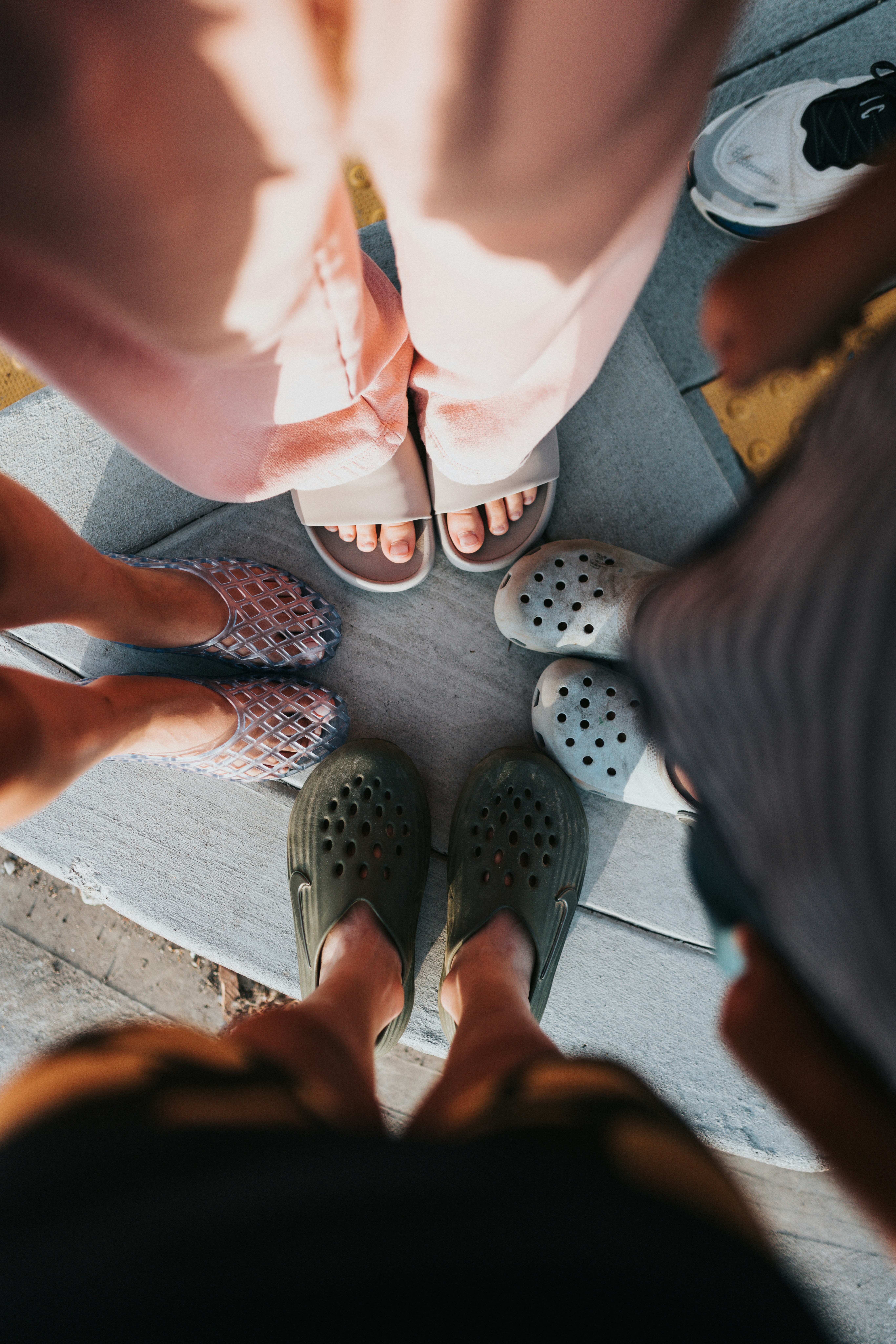 Multiple pairs of feet in various shoes forming a circle.