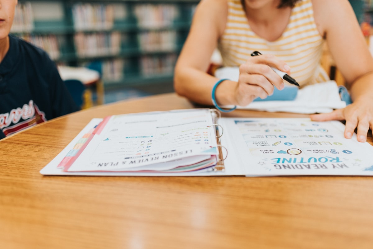 Student completing an AI-generated worksheet in an open binder, showing differentiated practice in 2026