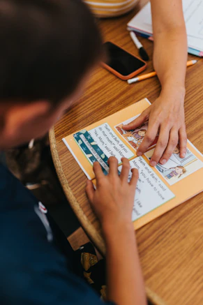 Two people learning together at a wooden table.