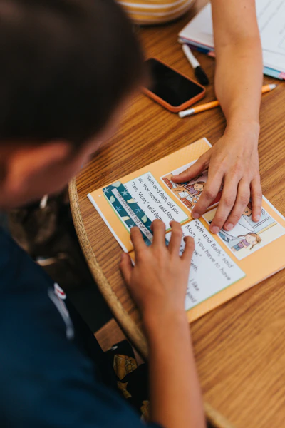 Two people learning together at a wooden table.