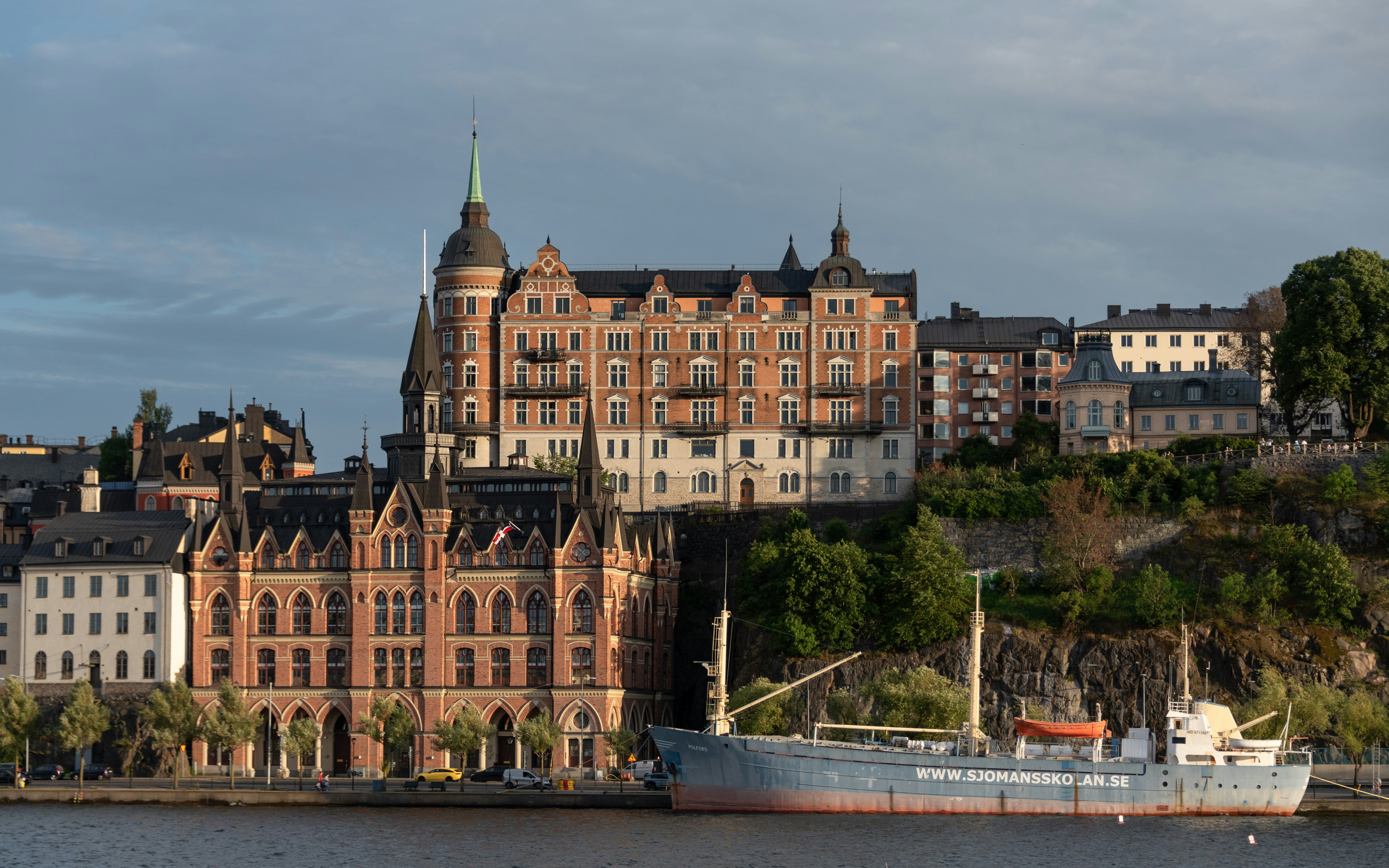 Grand building and ship docked on a city waterfront.