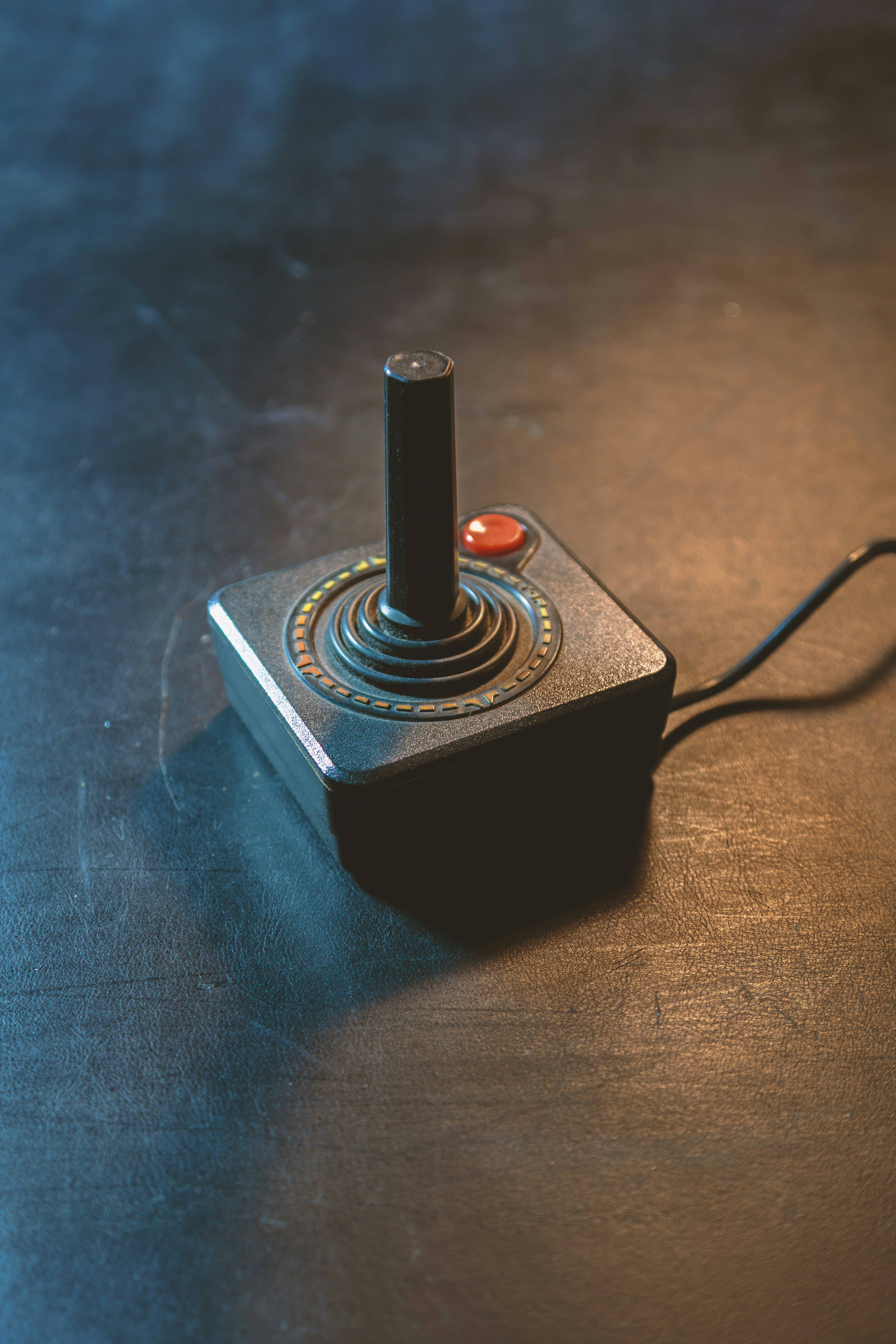 Retro black joystick with red button on dark background