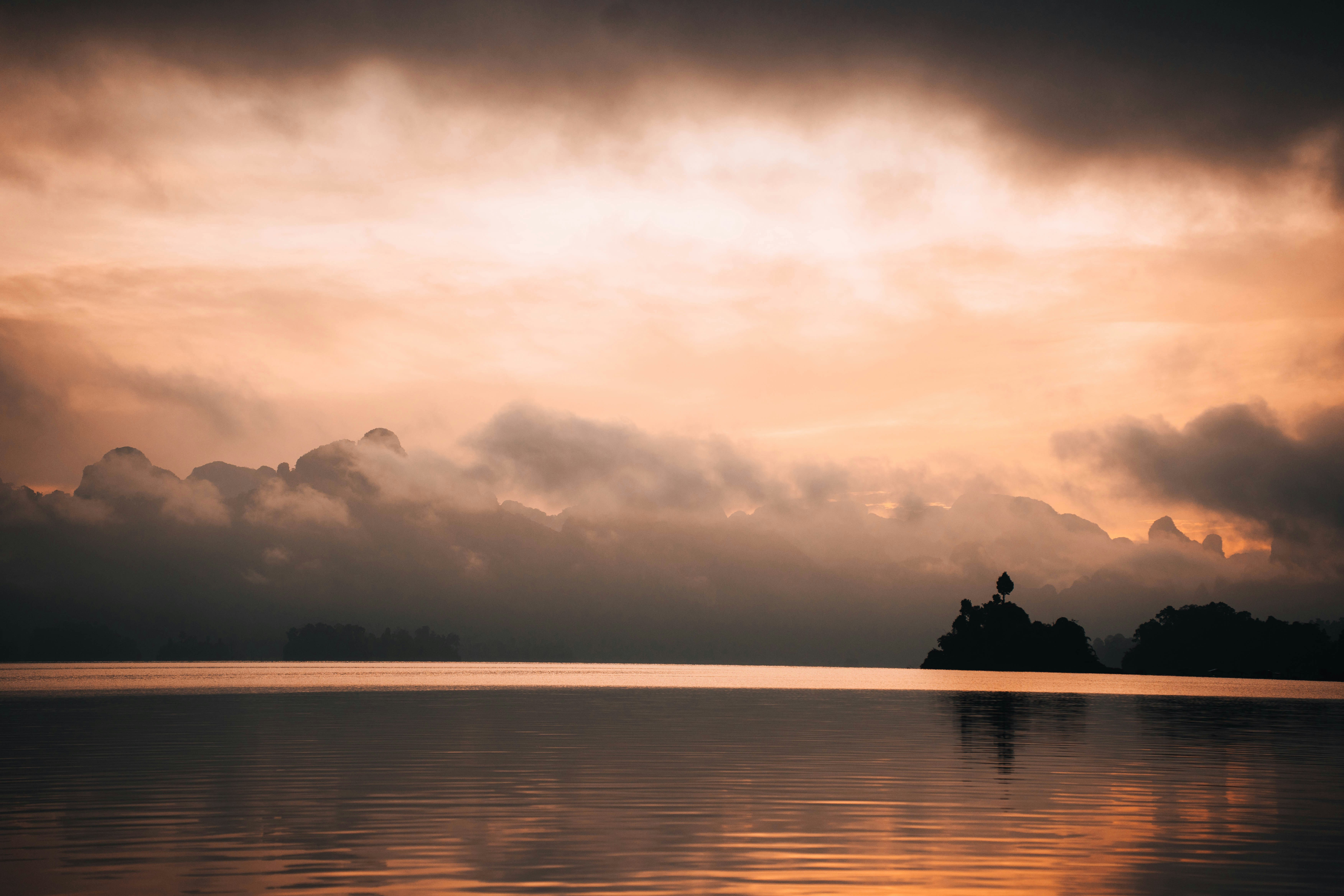 Dramatic sunset over a calm lake with distant land