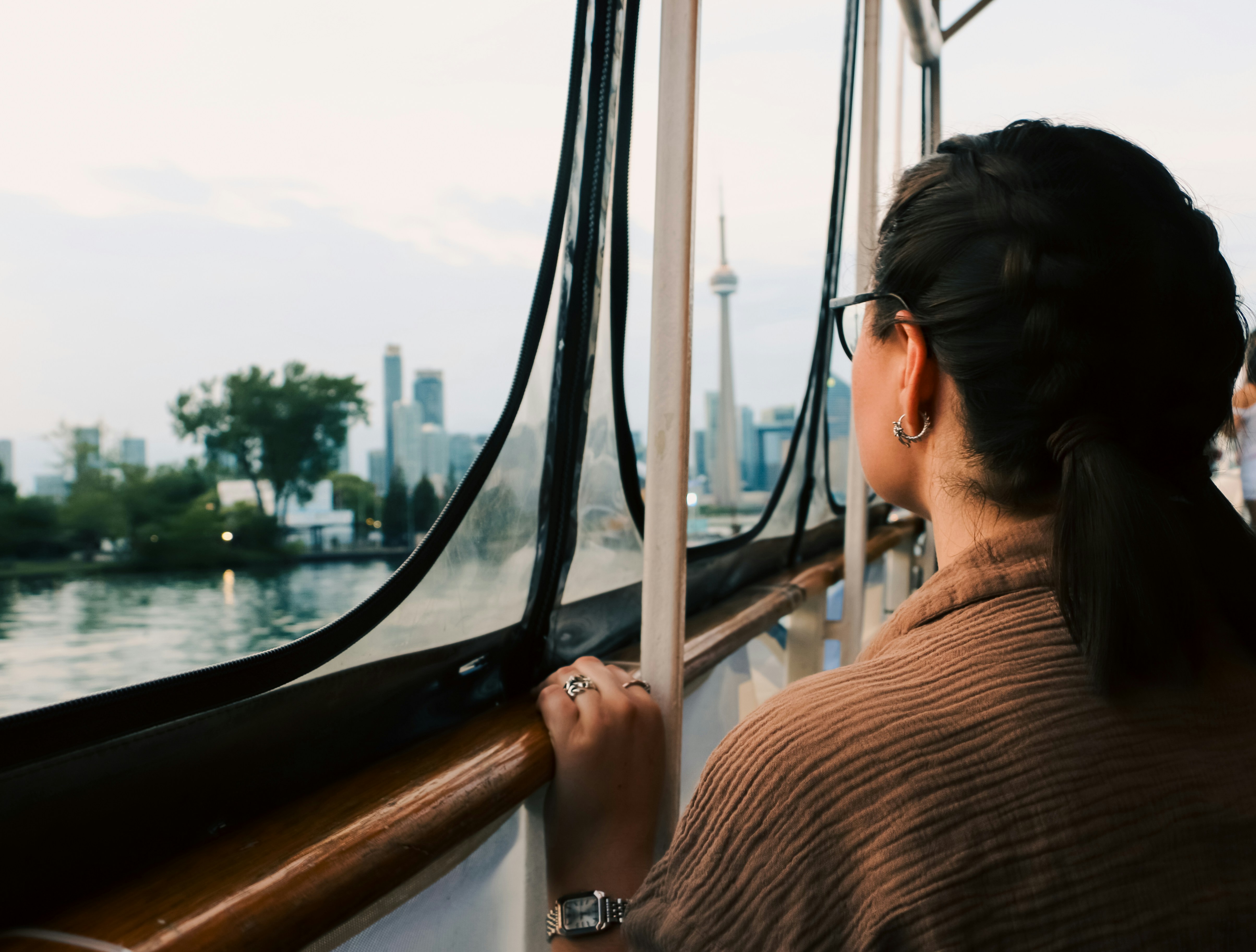 Woman on a boat observing the toronto skyline at dusk.
