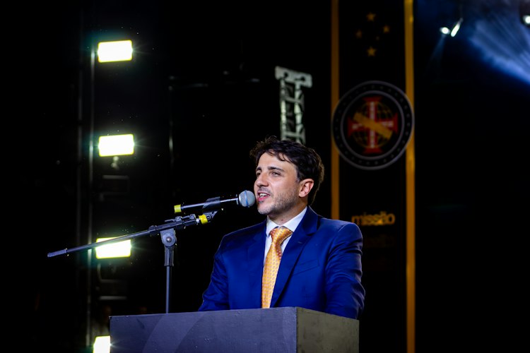 Person standing at a podium addressing an audience in a conference room