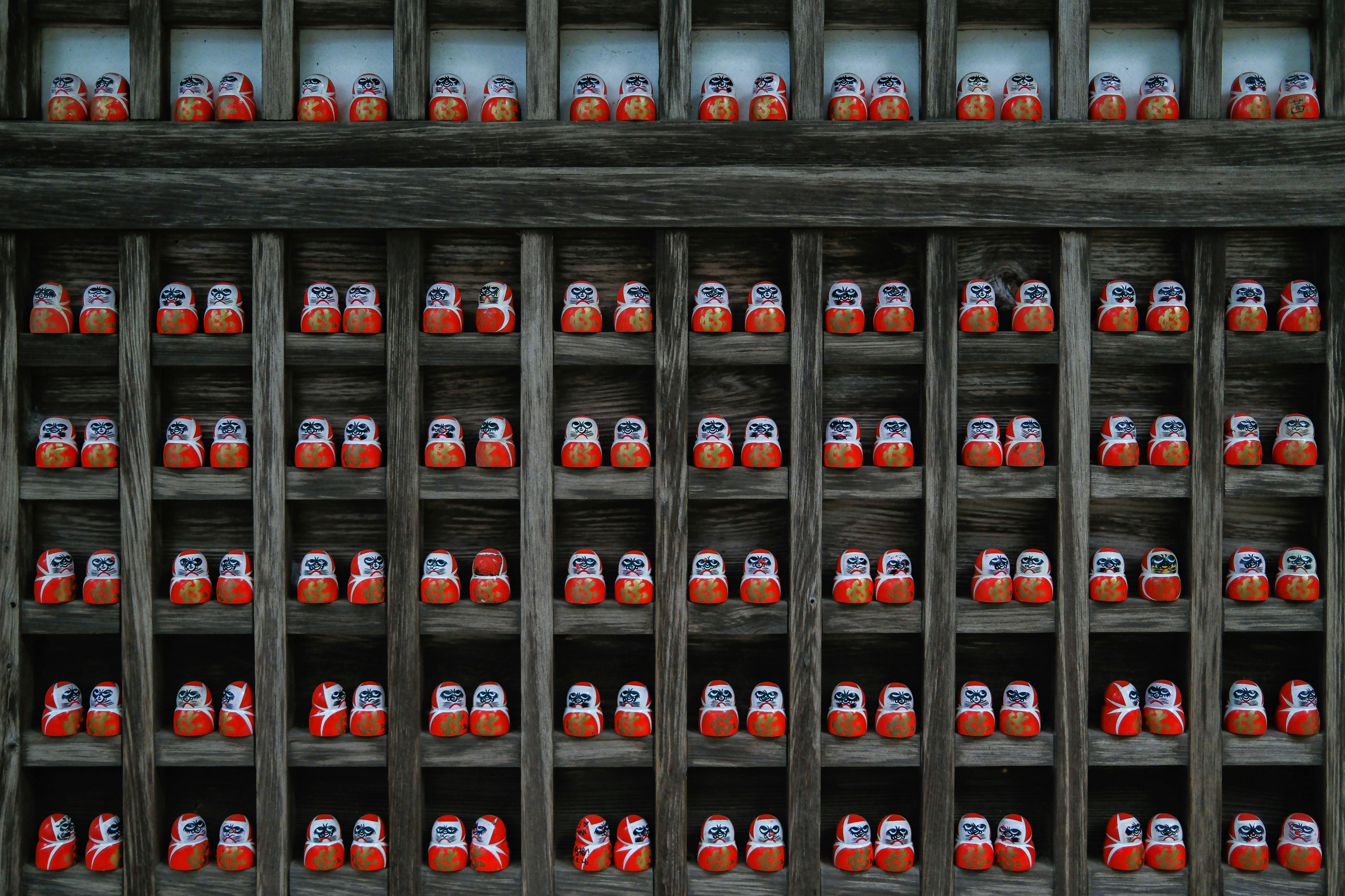 Rows of red and white figures in a wooden structure