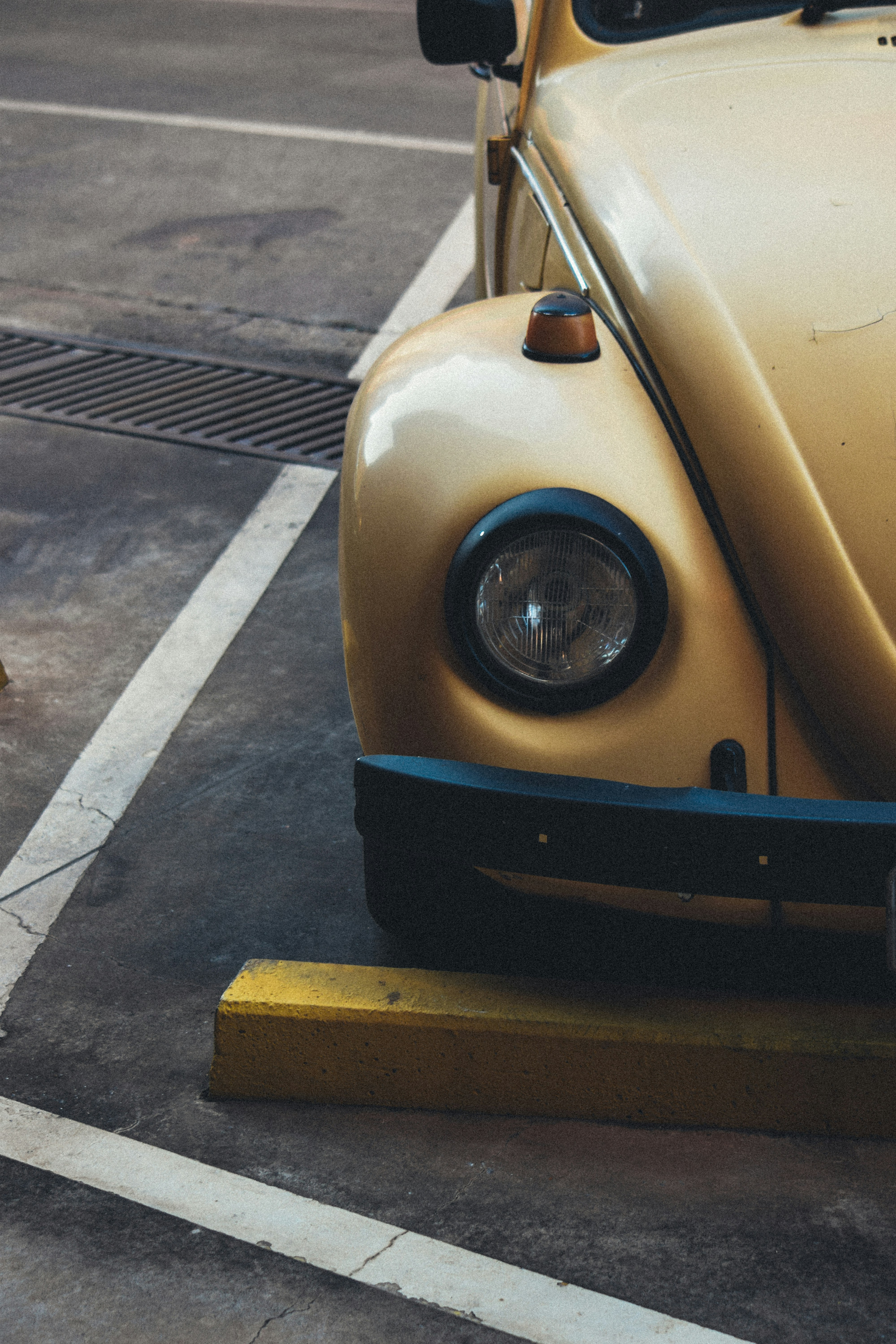 Yellow vintage car parked in a parking lot.