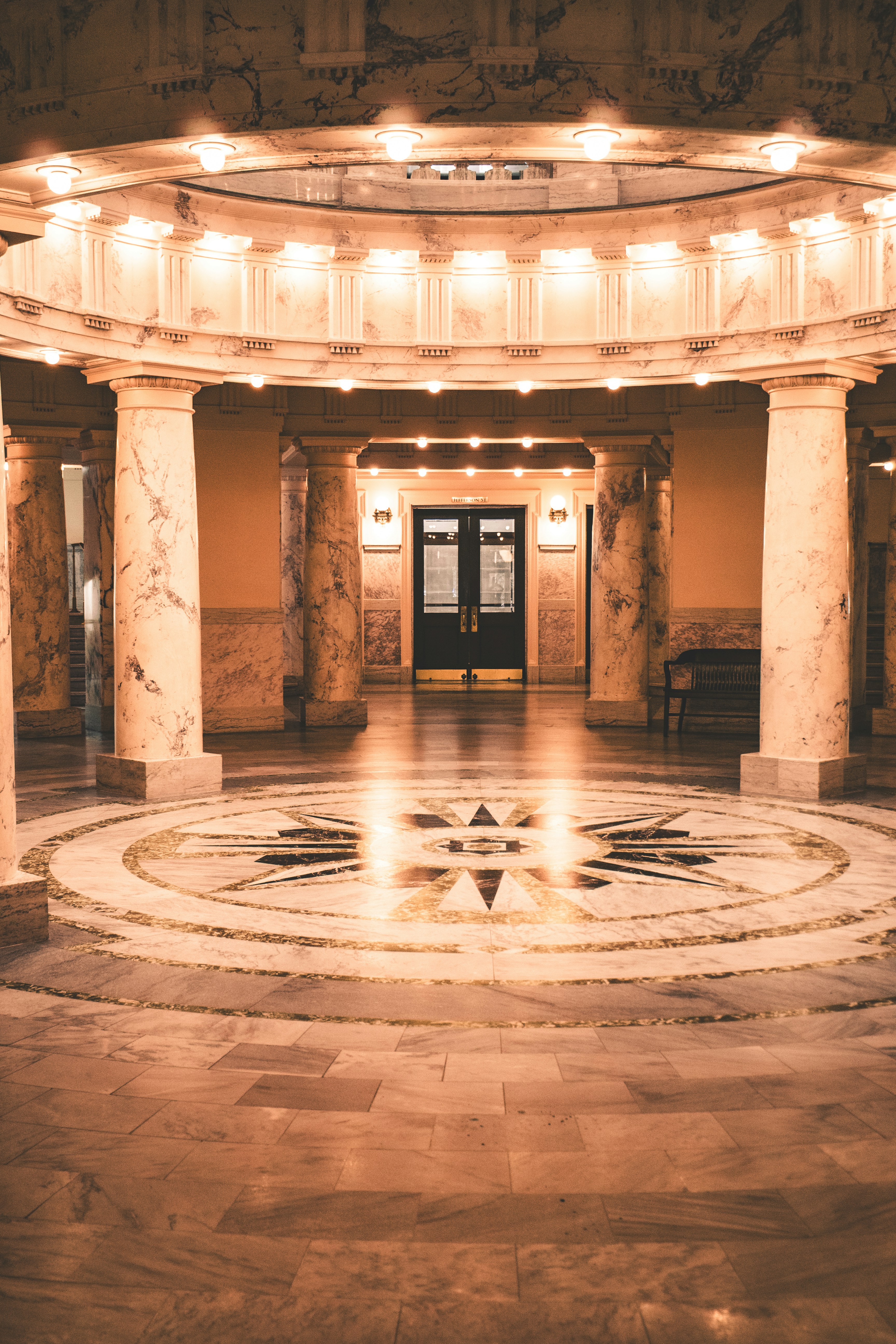 Interior ornamentado del salón con columnas de mármol y suelo con patrones de estrellas.