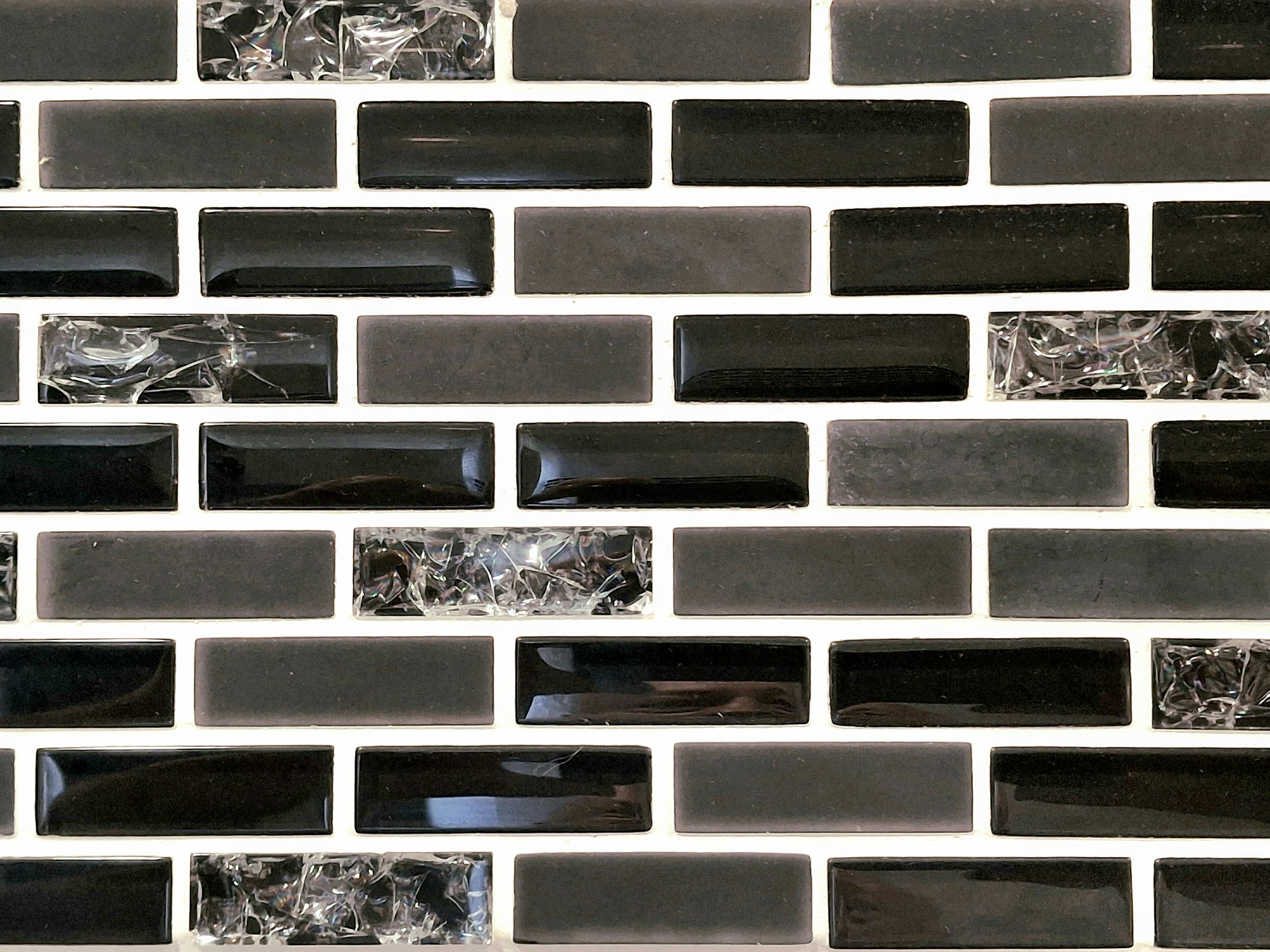 Black, grey, and marbled rectangular tiles with white grout pattern.