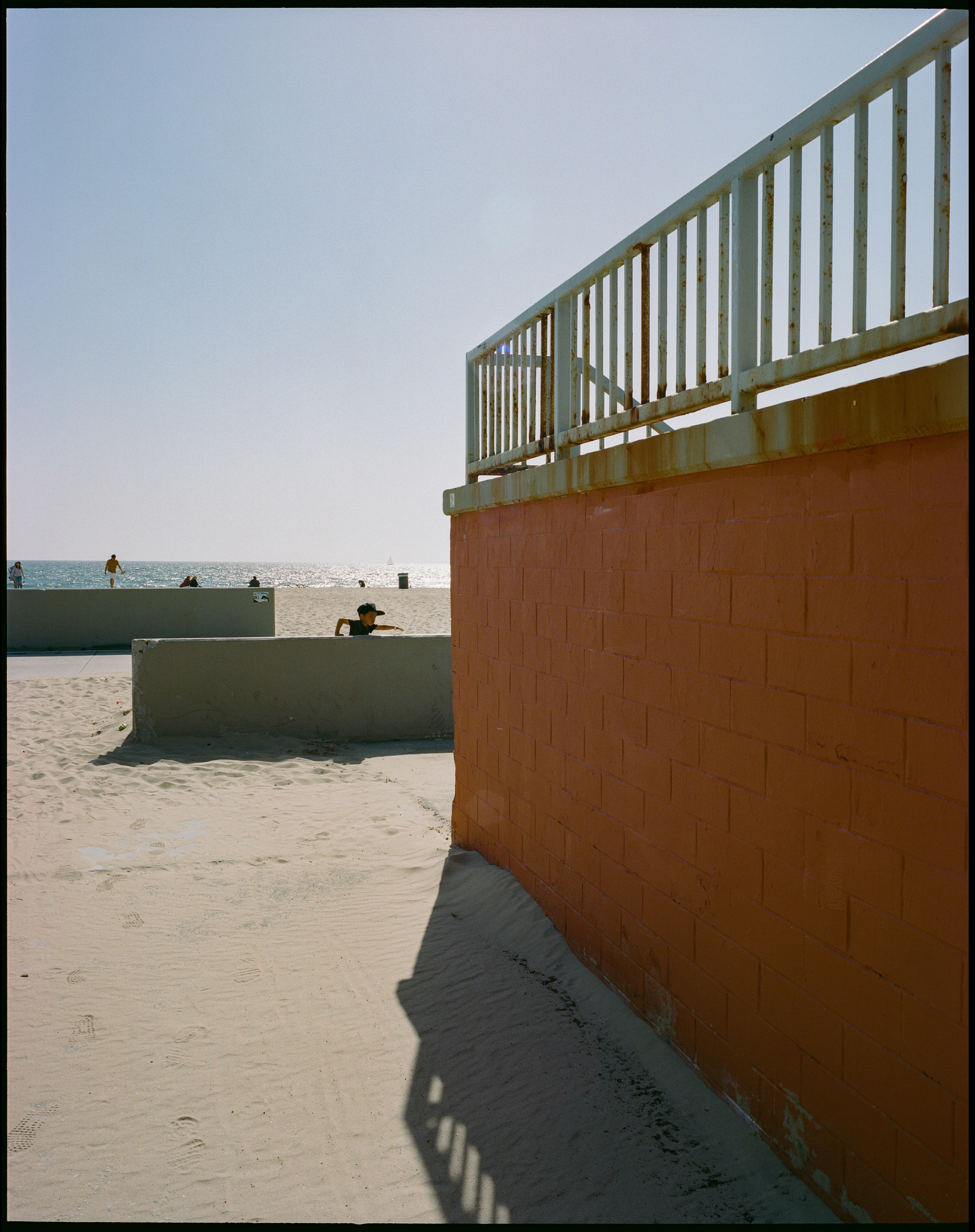 Orange wall and railing overlooking venice beach