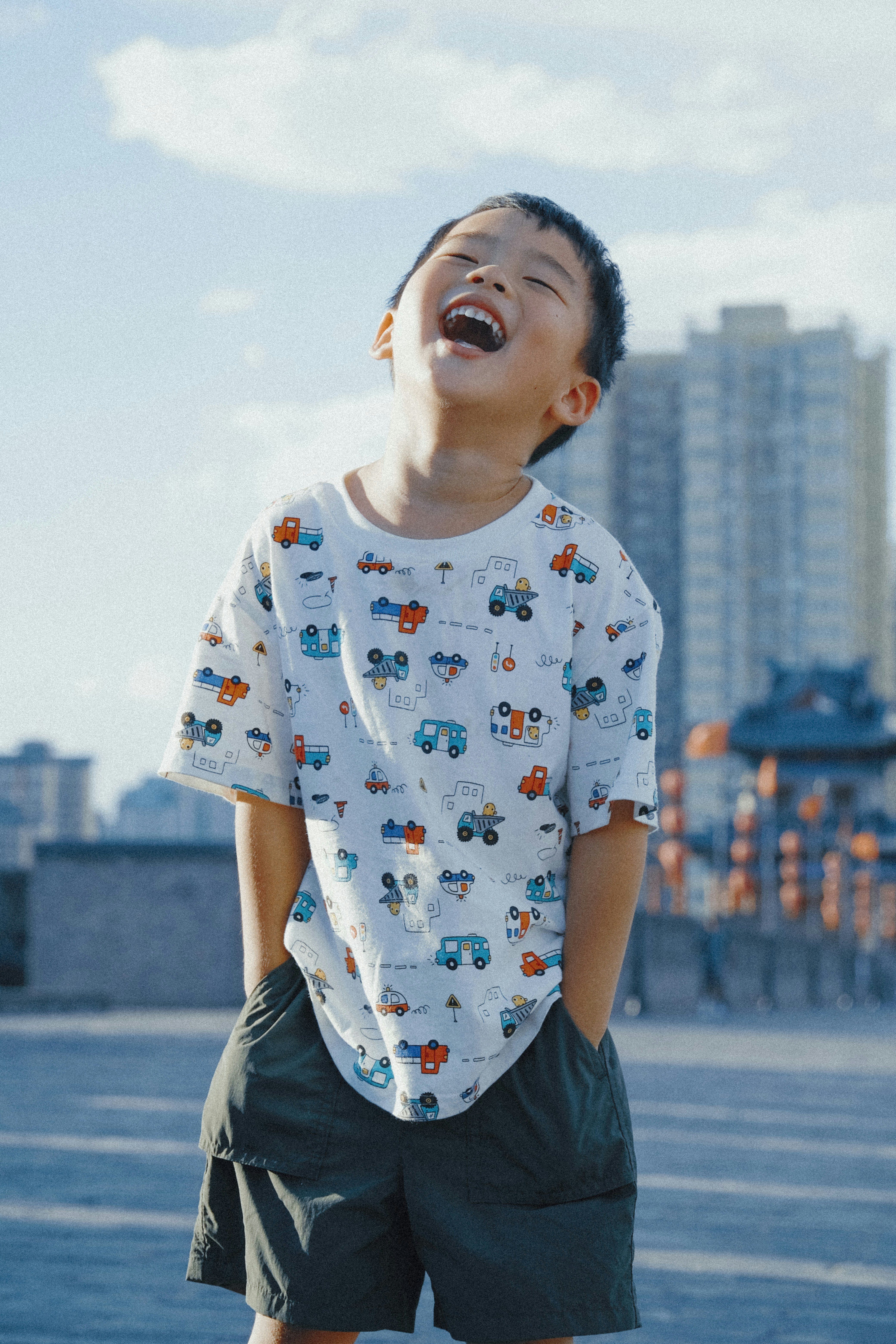 Boy laughing happily outdoors against city skyline