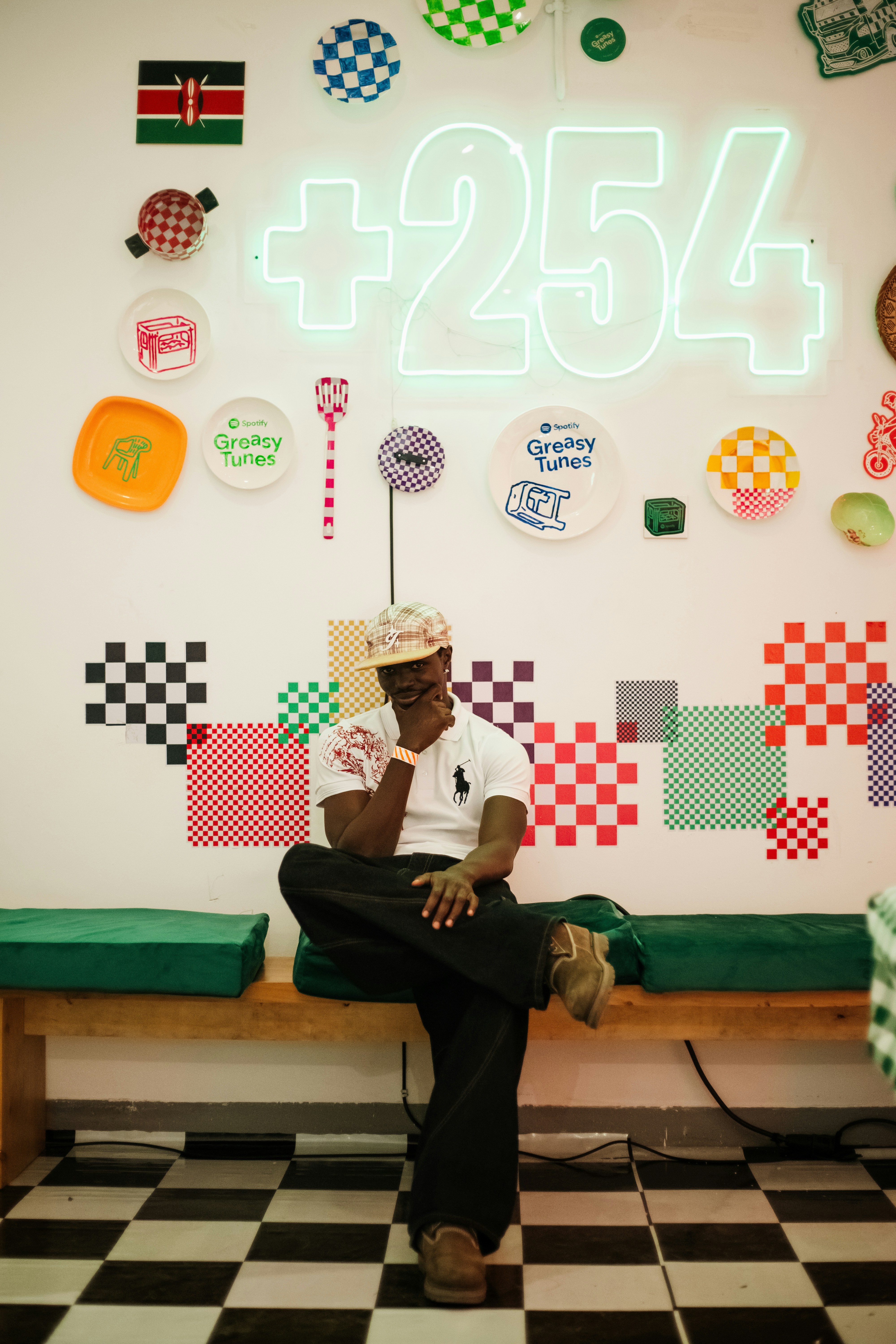 Man smiles on bench in a vibrant, patterned room