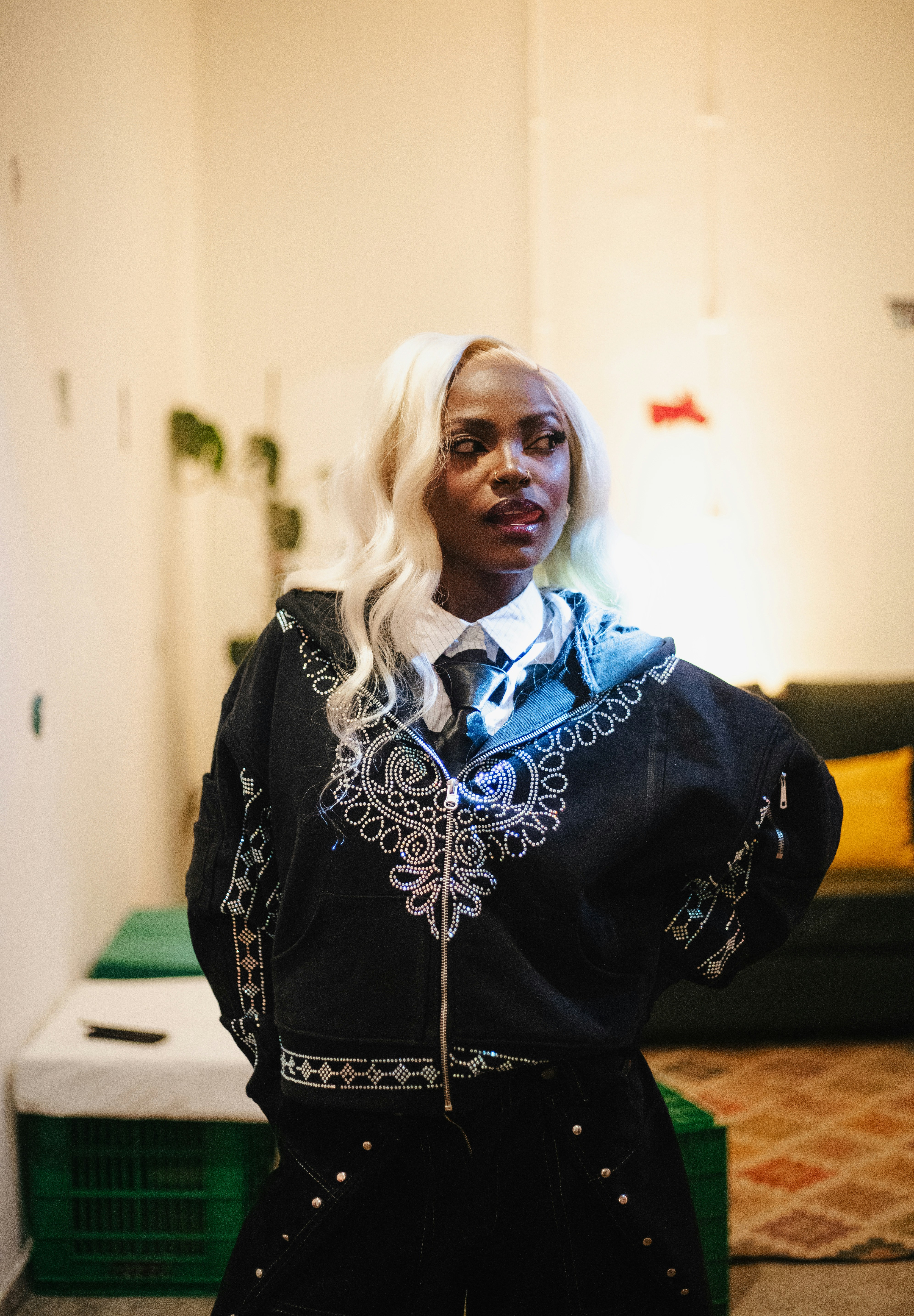 Stylish woman with blonde hair in black embroidered jacket.