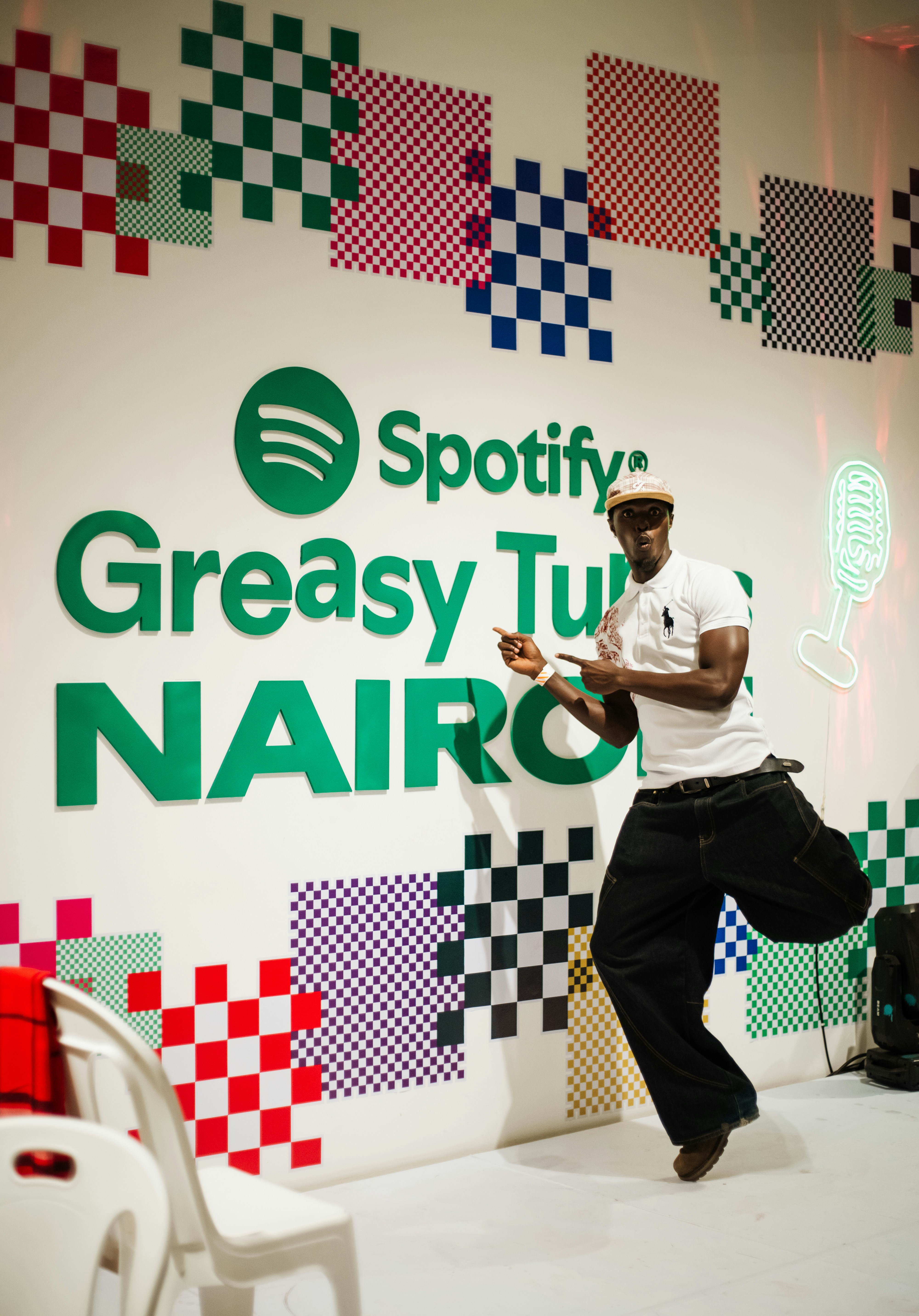 Man jumps in front of spotify greasy tunes nairobi wall.