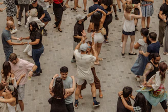 Many people dancing together outdoors in a public square