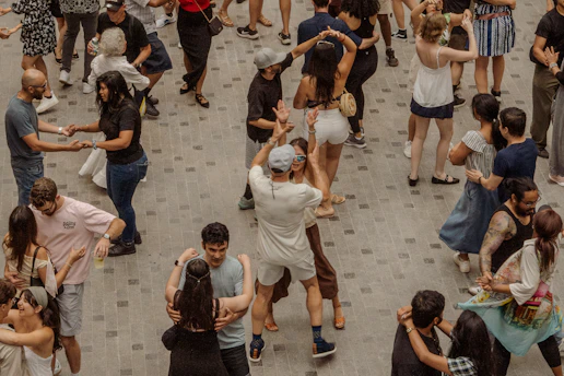 Many people dancing together outdoors in a public square
