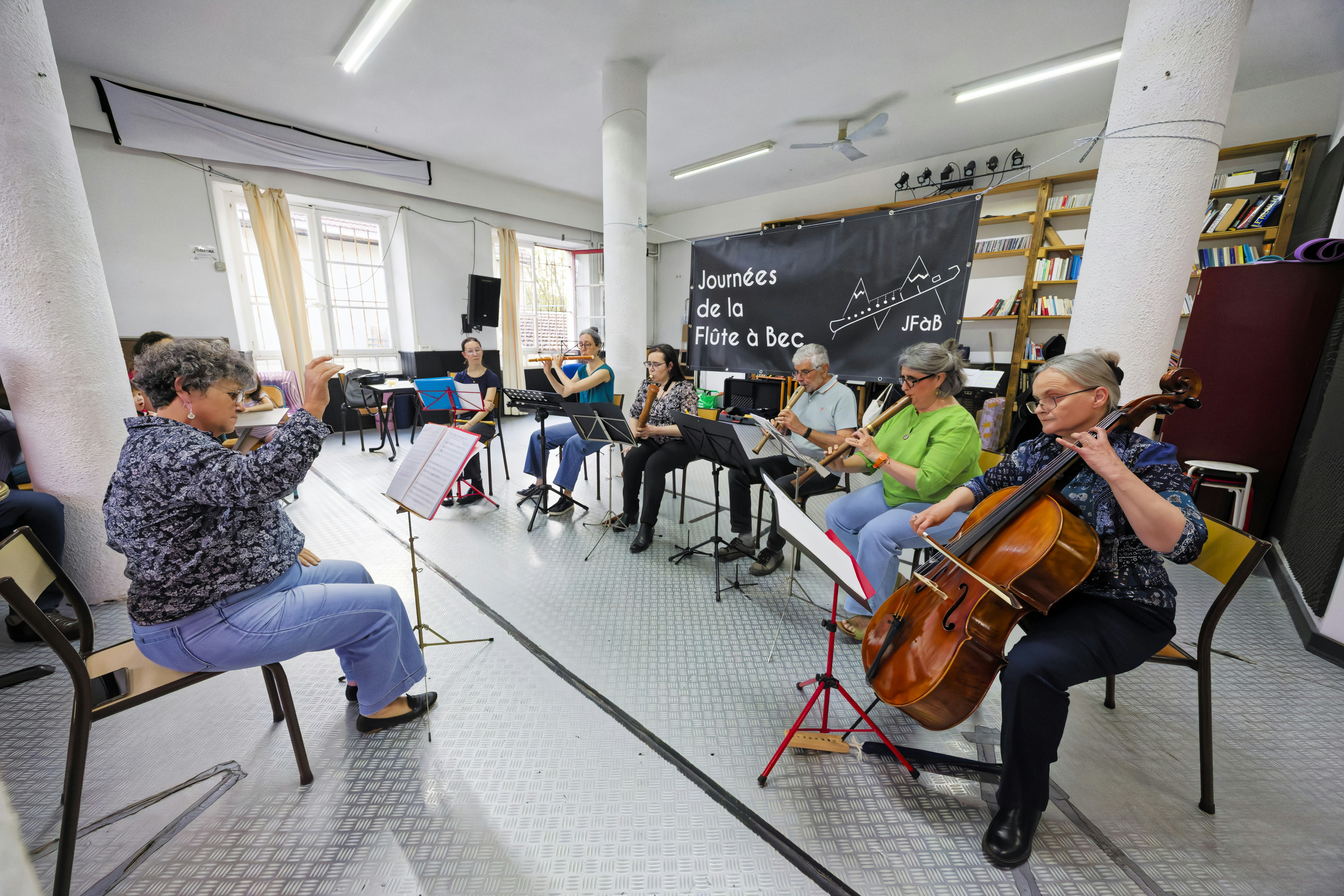 Senior musicians rehearsing with string and wind instruments indoors