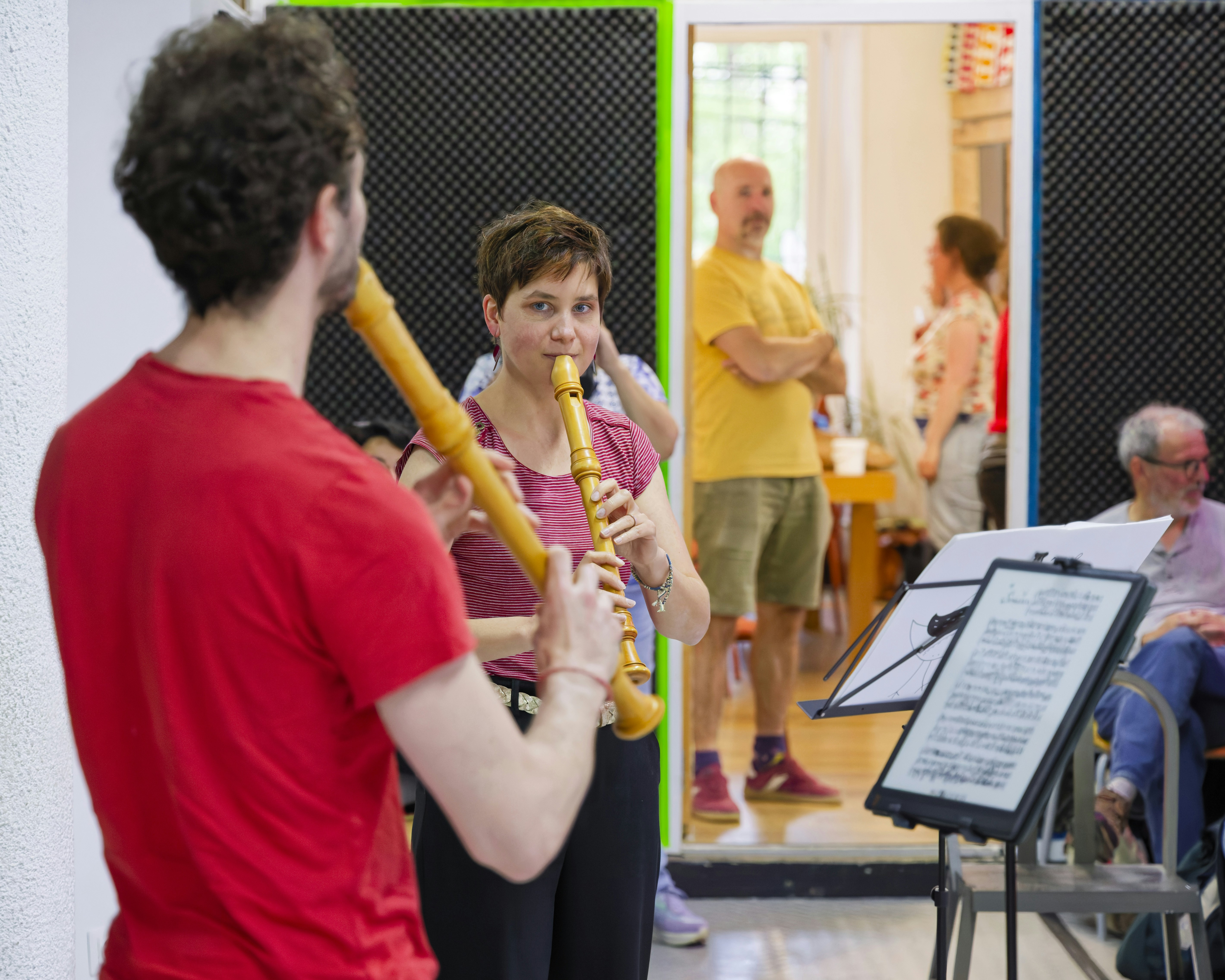 Dos personas tocando la flauta dulce en una clase de música