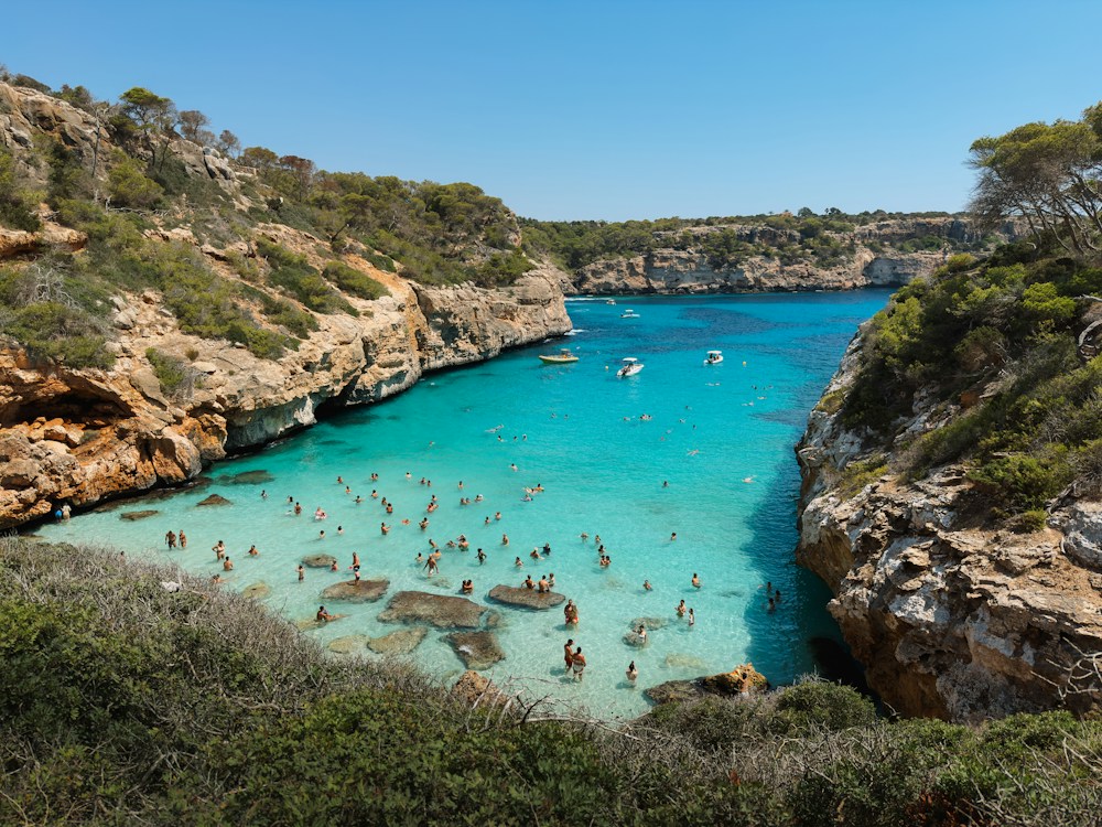 A wide bay of bright blue water between rocky headlands