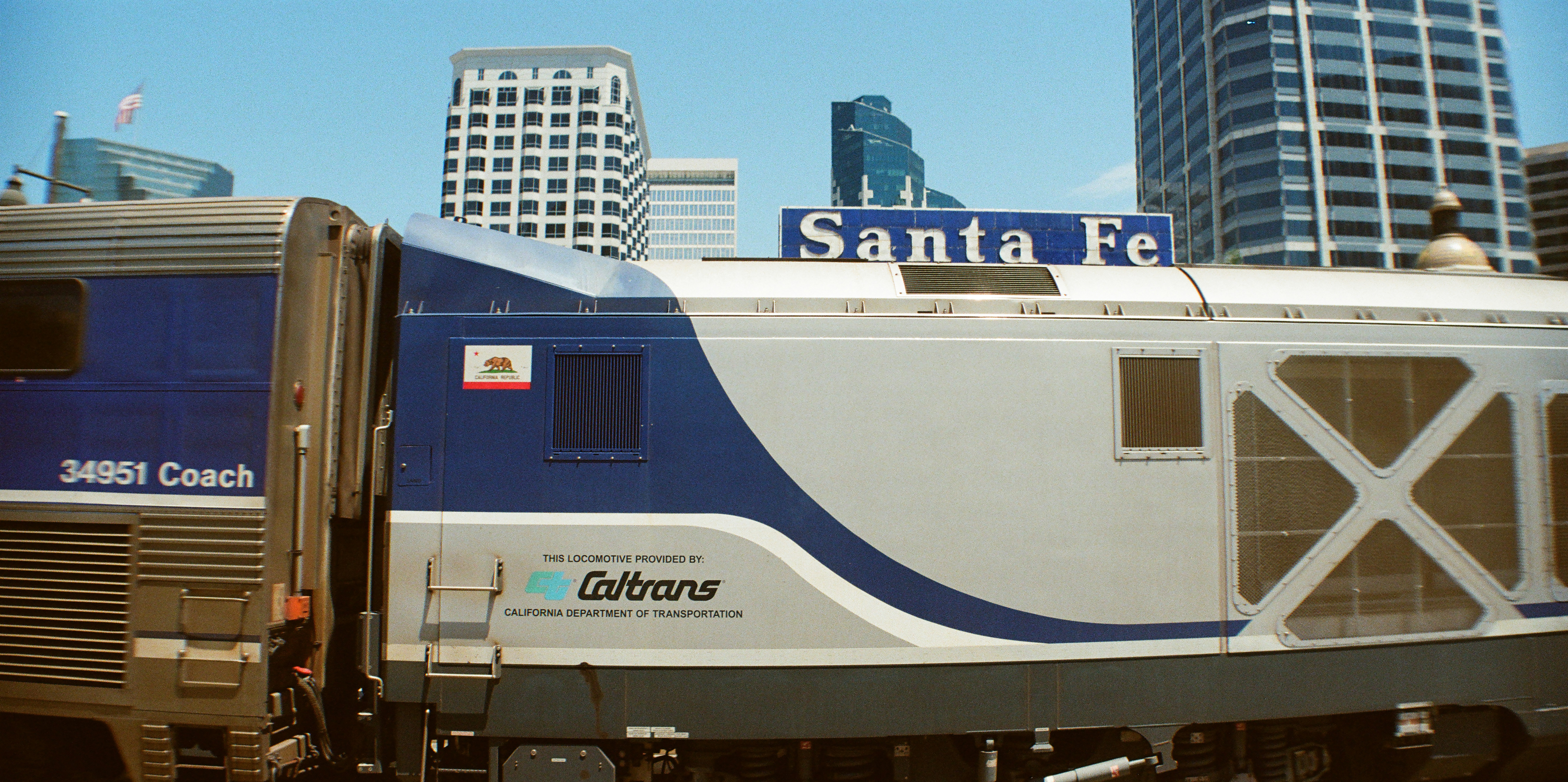 A santa fe train with caltrans branding in a city