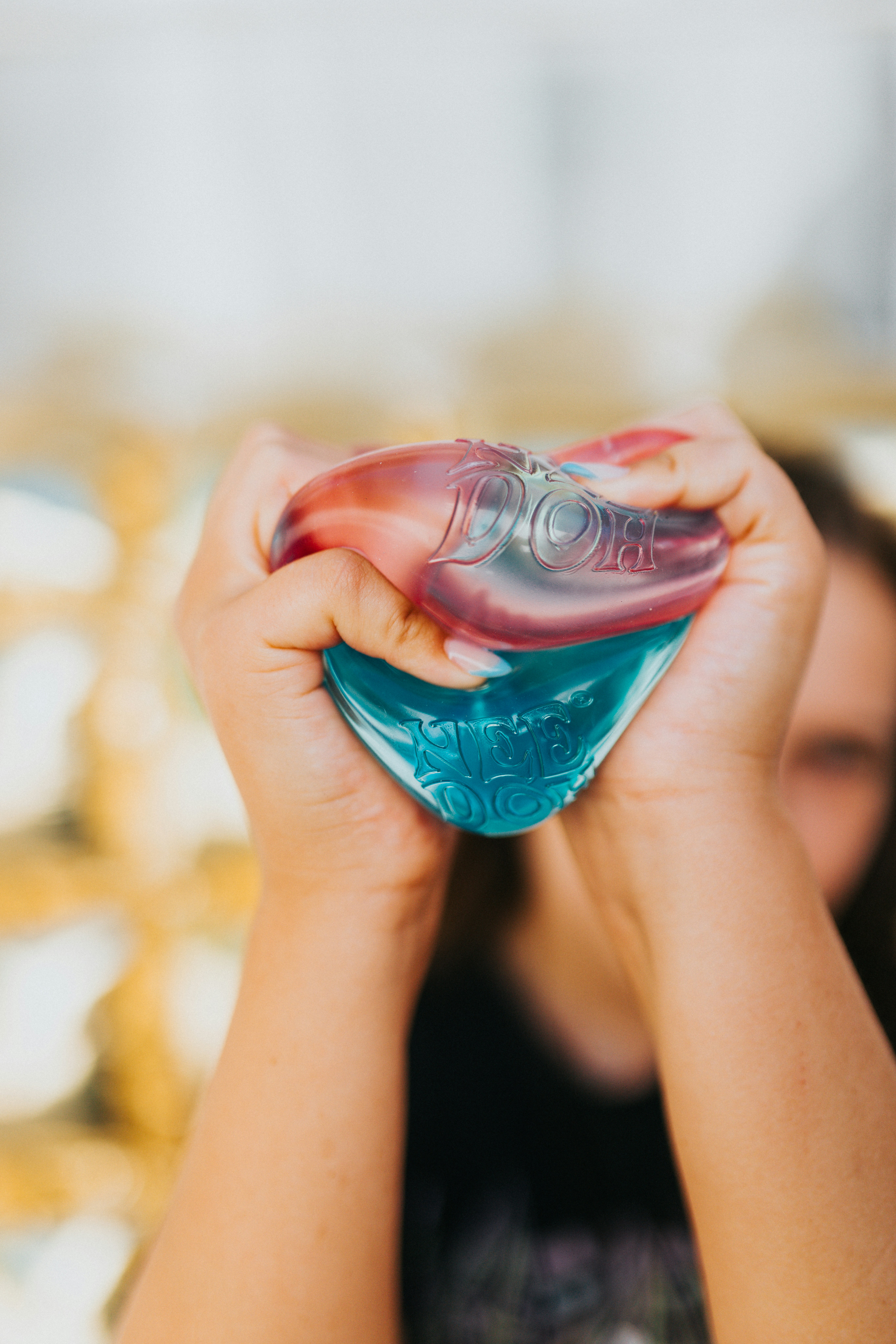 Hands squeezing a red and blue dove bottle.