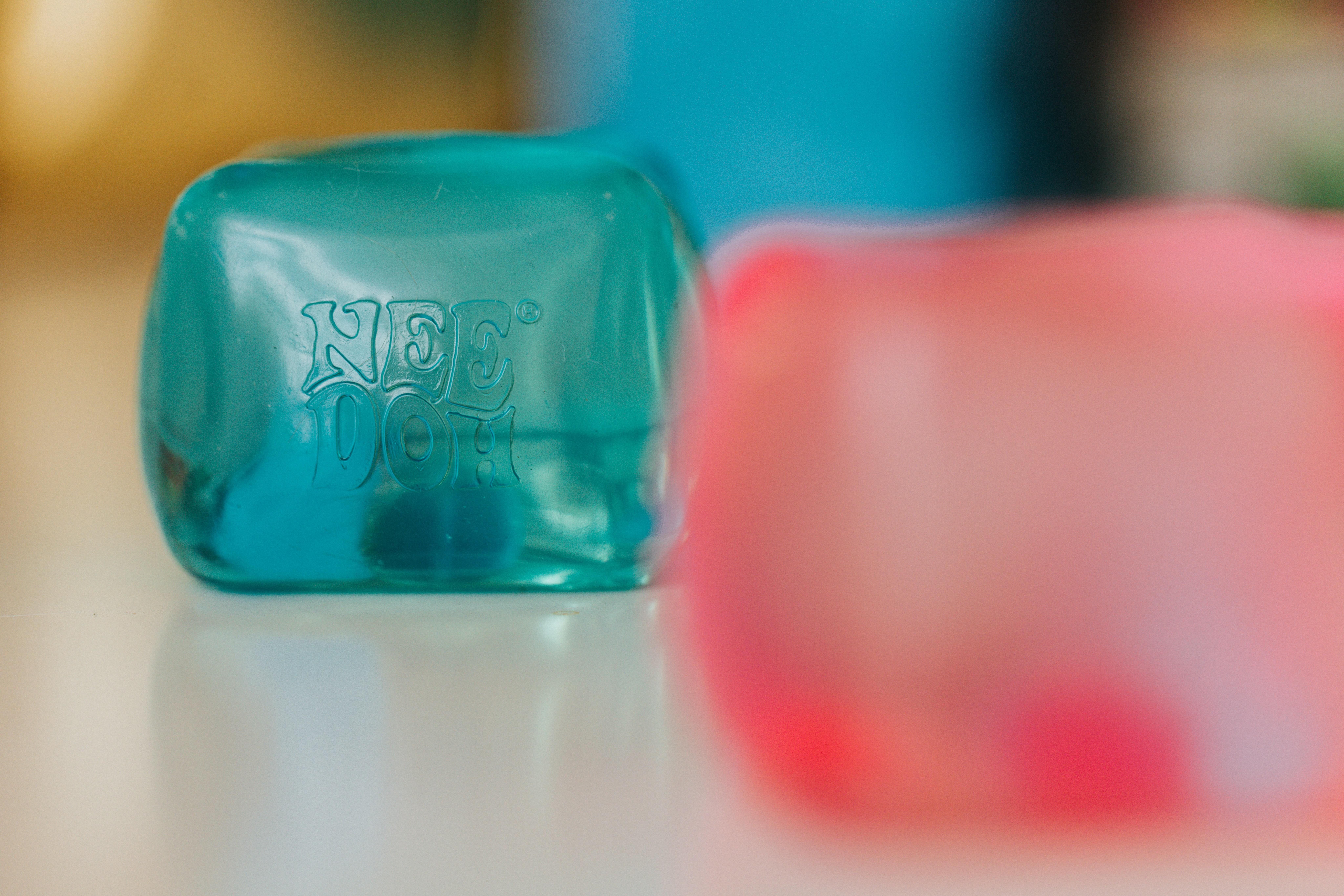 Teal cube with "not yet" text, blurred pink cube nearby.