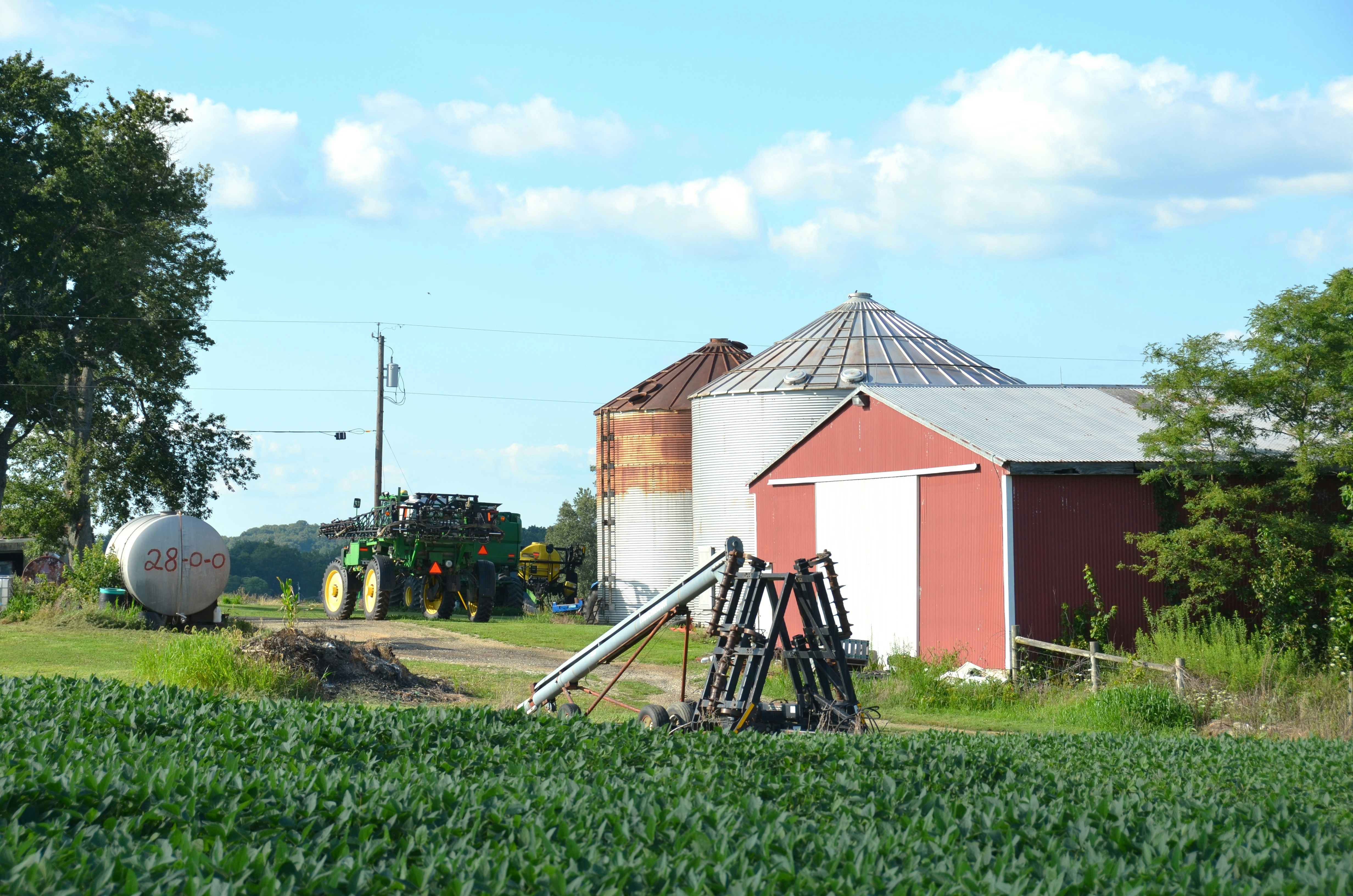 Rural farm scene with barn, silos, and tractor.