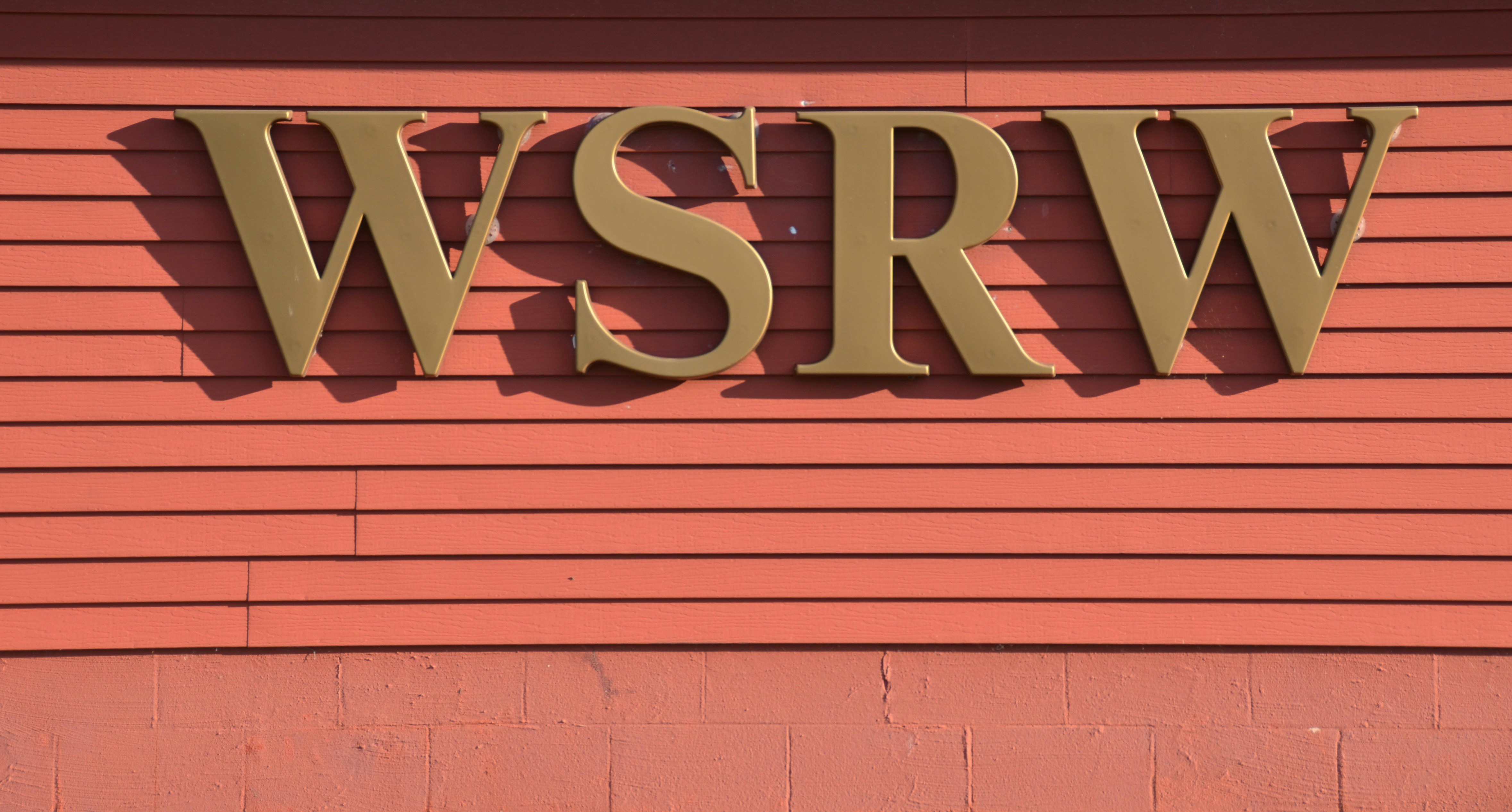 Gold "wsrw" letters on a red wooden wall.