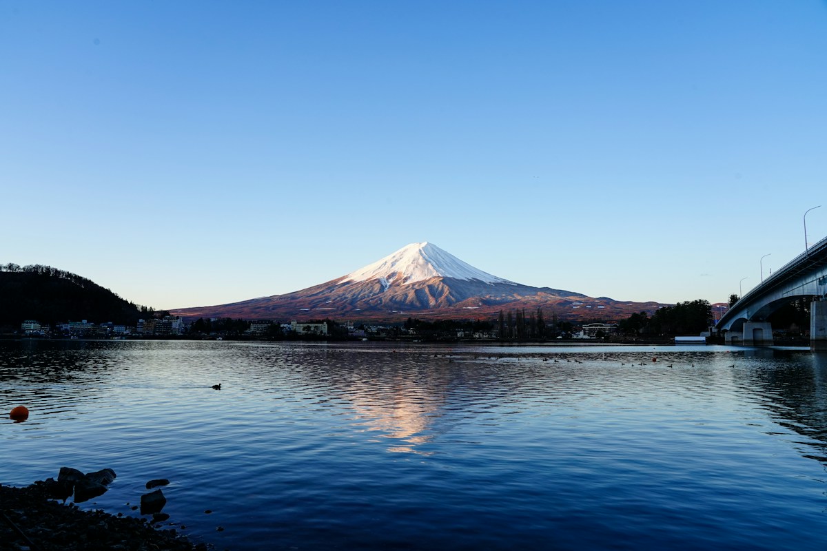 Snow-capped Mount Fuji mirrored in a calm lake at Kawaguchiko