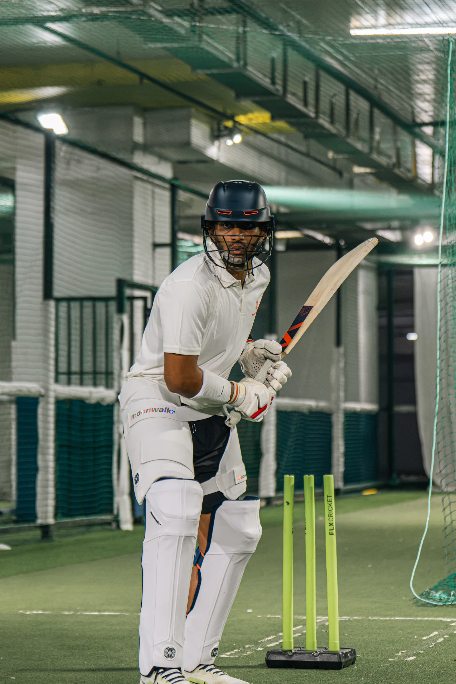 Cricketer in batting stance with bat and stumps