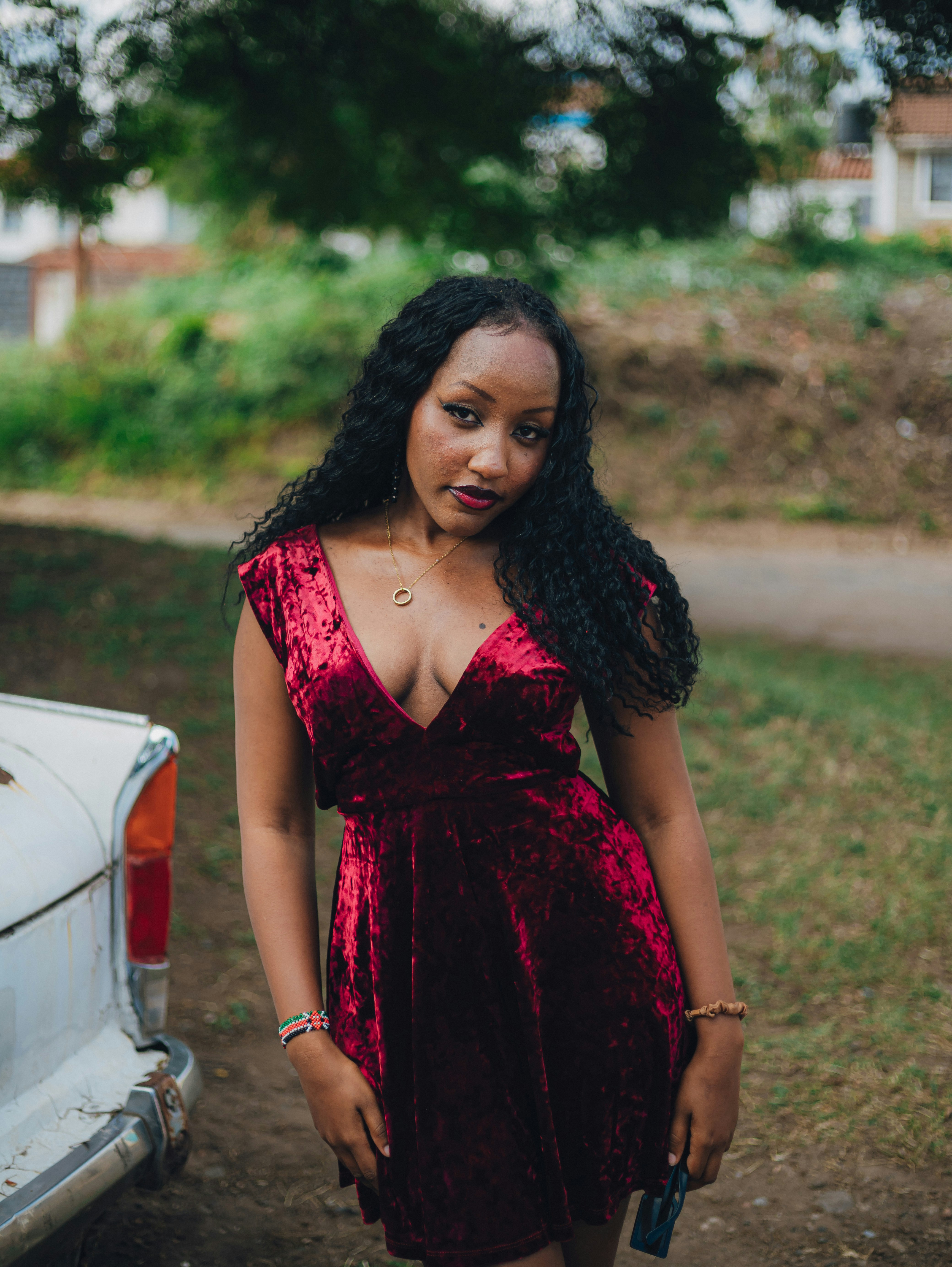 Una joven con un vestido de terciopelo rojo de pie al aire libre
