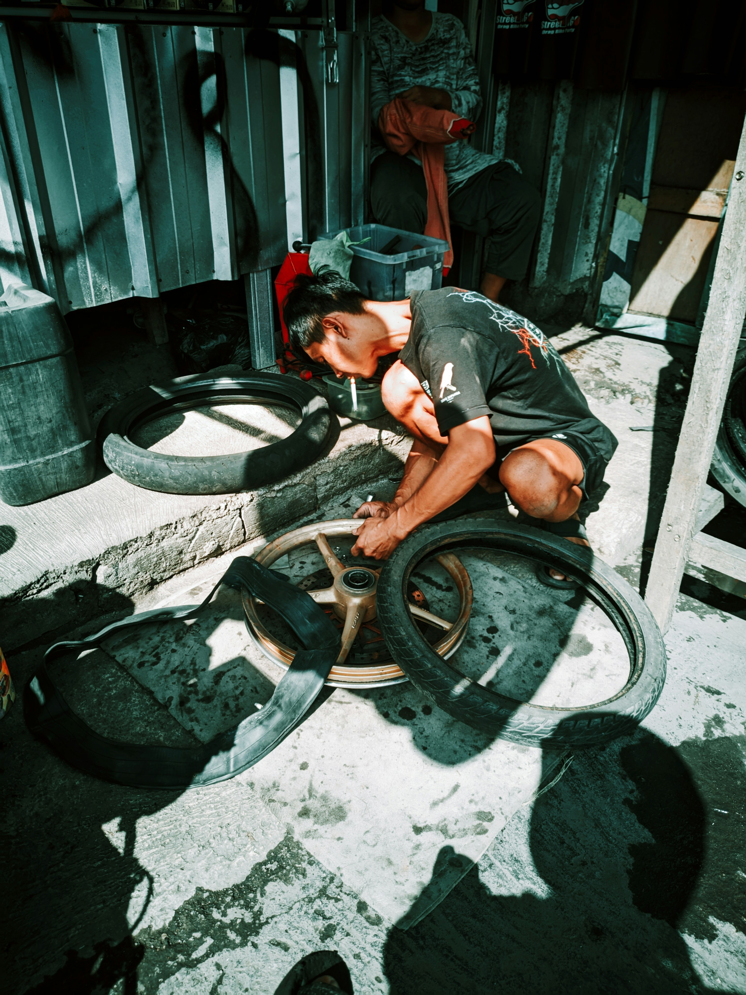 Man repairing motorcycle wheels and tires in a workshop
