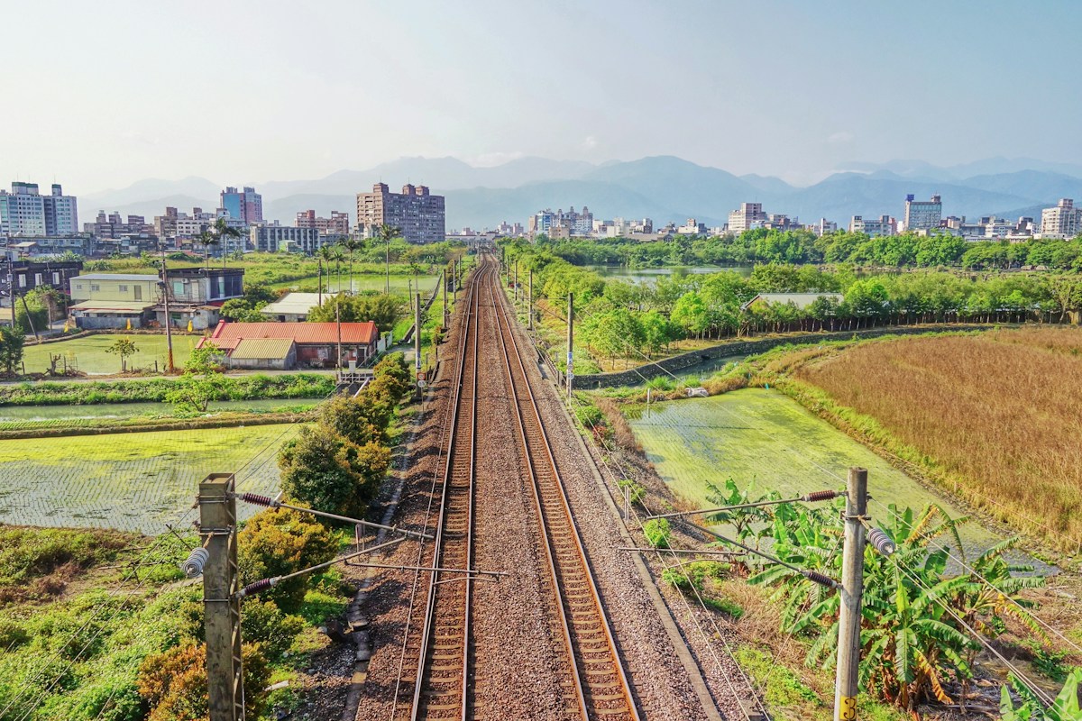 羅東一帶的鐵道穿過稻田，遠方是市區與山脈