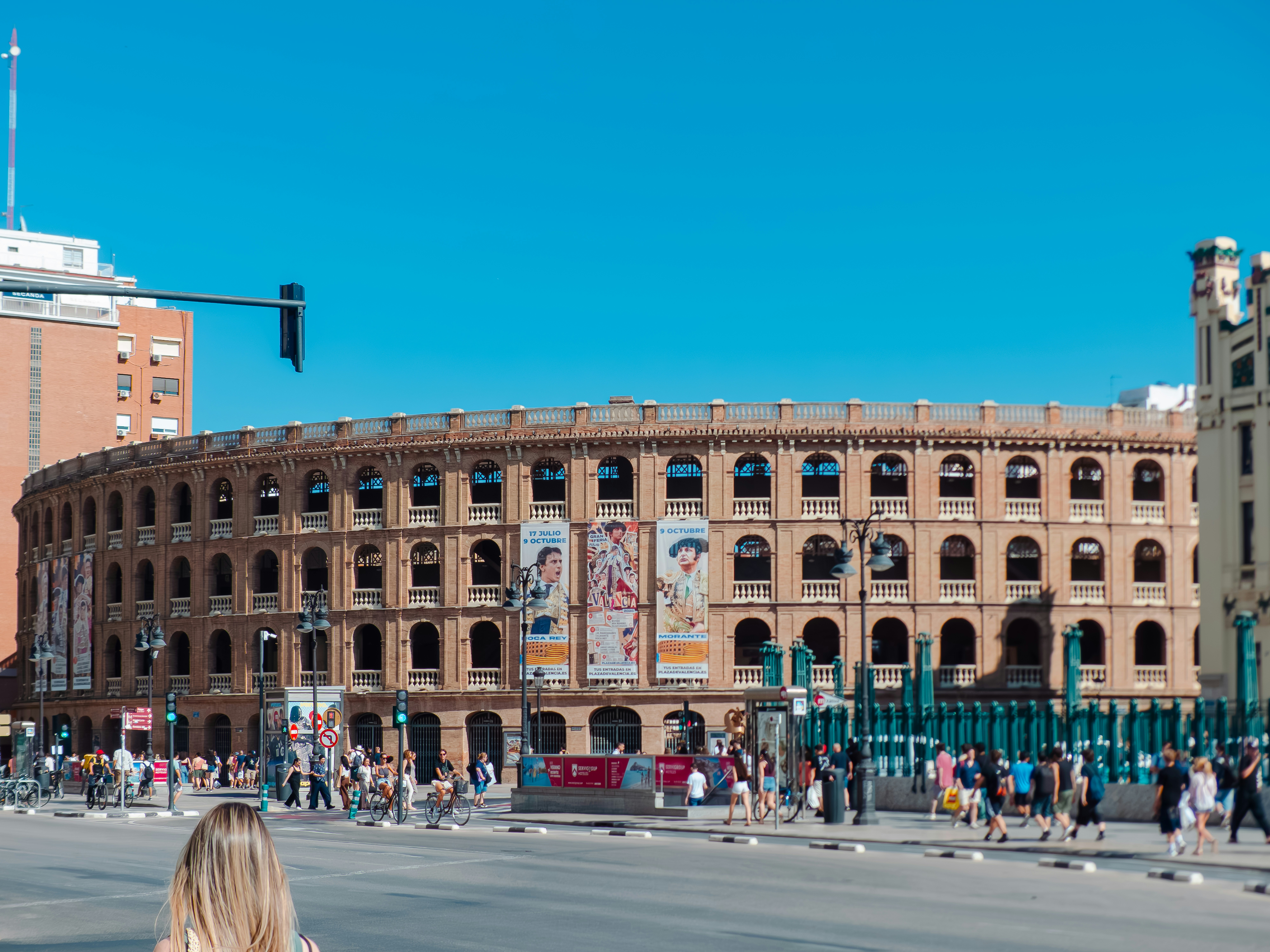 The Plaza de Toros bullring in Valencia with people walking on the street