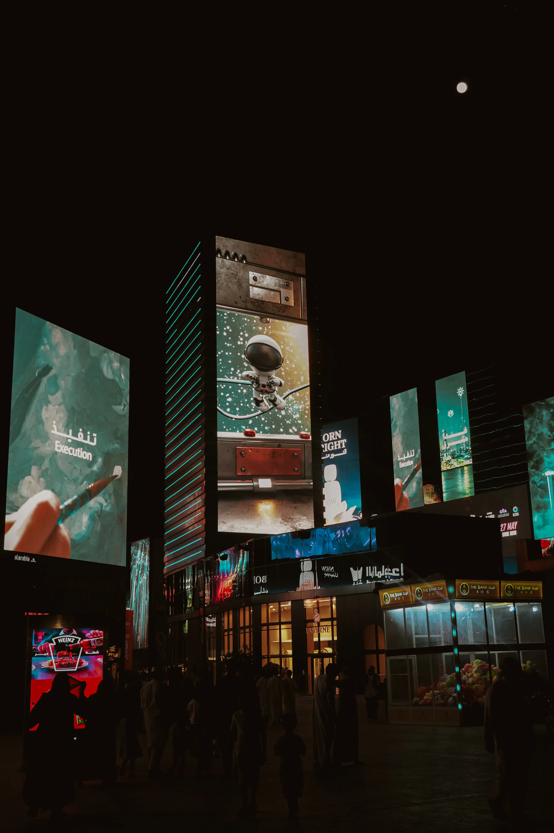 Vibrant cityscape at night with illuminated billboards and people