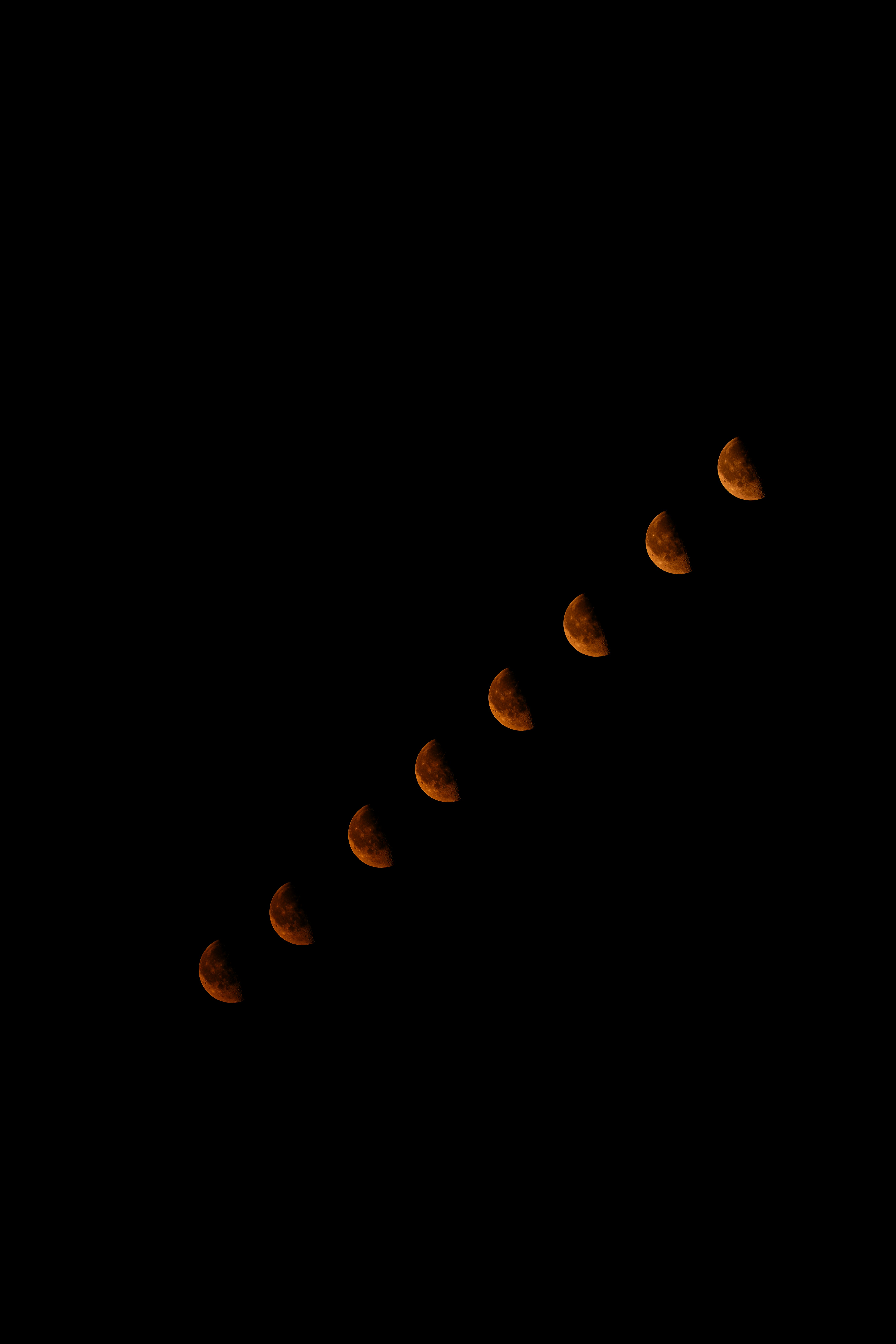 Lunar eclipse phases diagonally across a dark night sky.