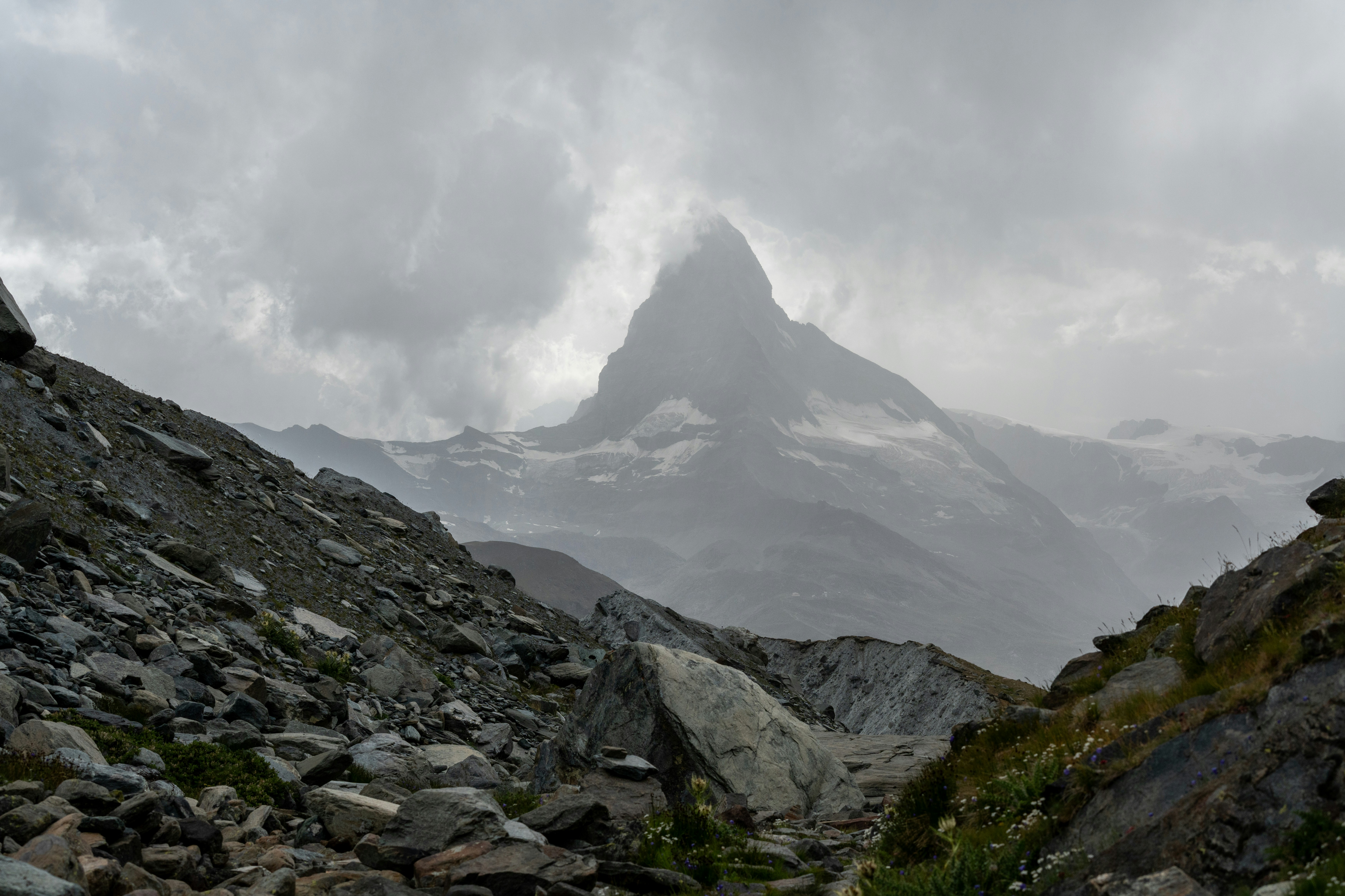 Un Cervin enveloppé de nuages dominant le paysage rocheux de Zermatt